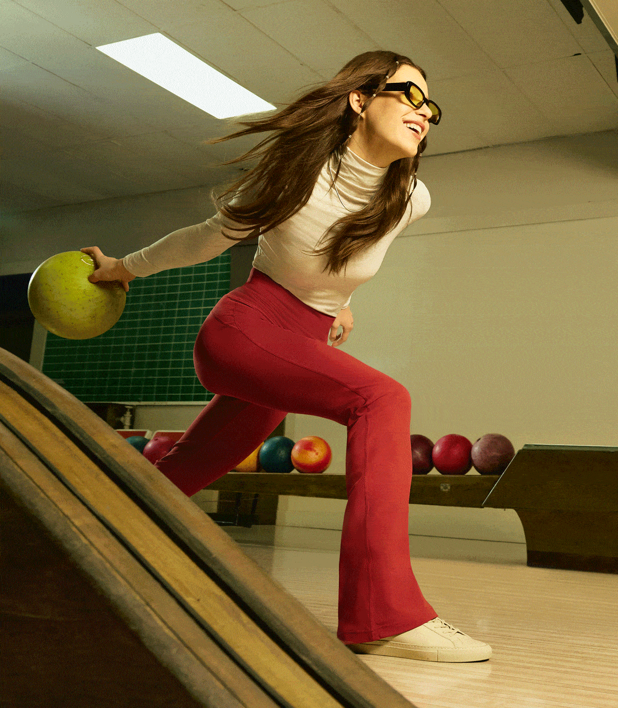 An animated GIF shows two people in various poses at a bowling alley. One wears the Groove Flared Pant and the other wears the Align Wide-Leg Pant.