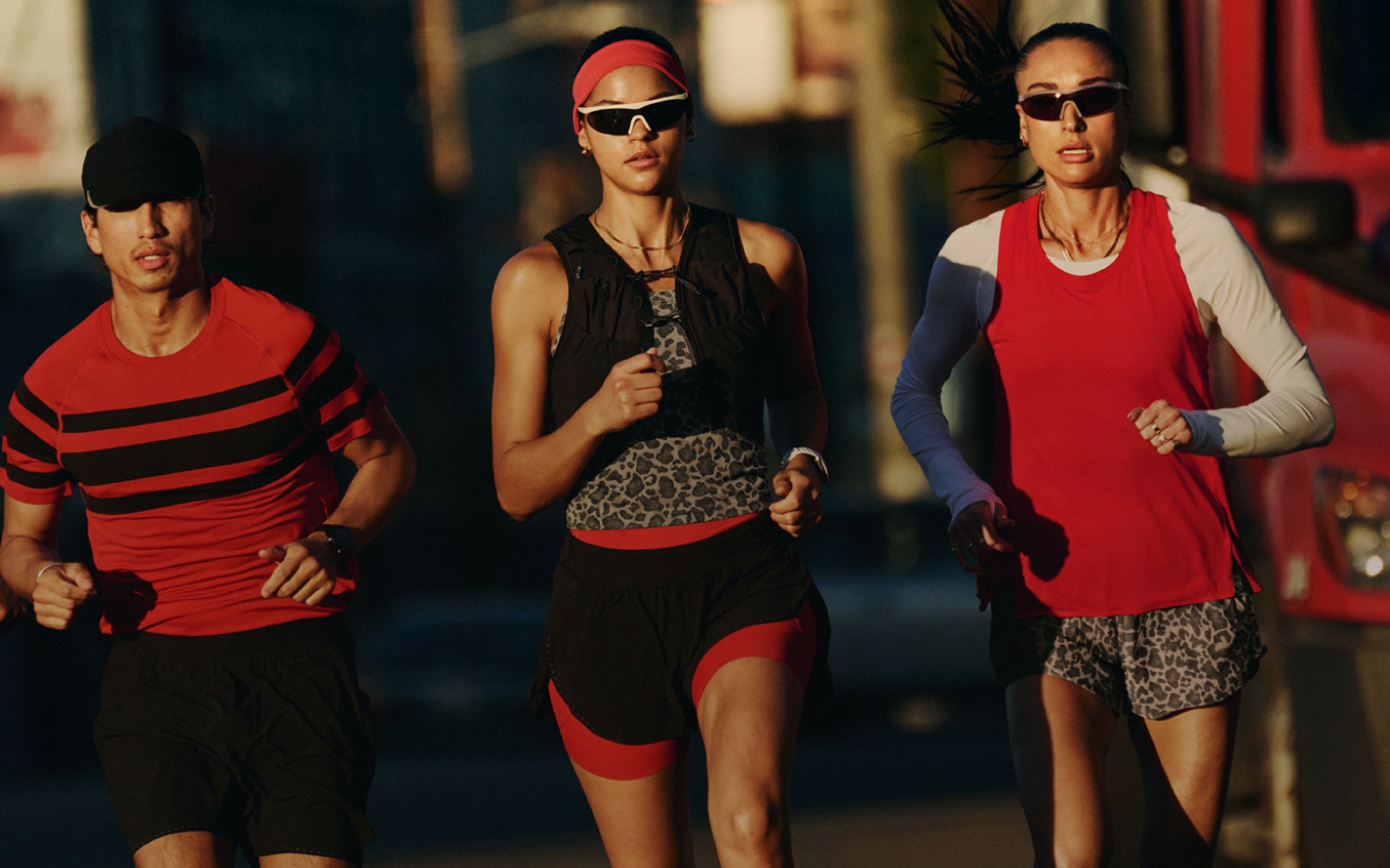 Ein Läufer und zwei Läuferinnen joggen durch eine Stadt und tragen die neue lululemon Laufkollektion.