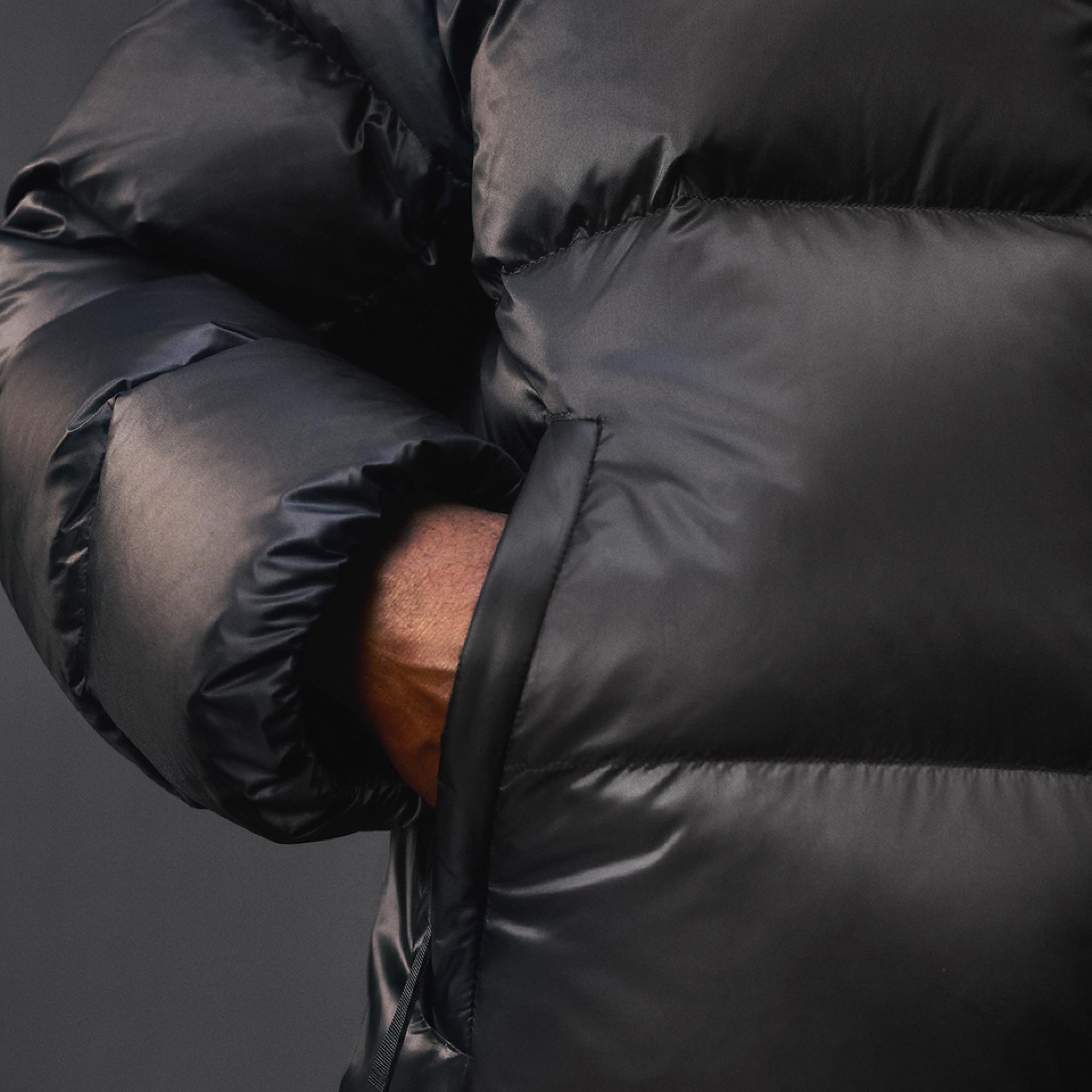 A close-up of a person wearing the Always Down Puffer Jacket with their hand in a pocket.