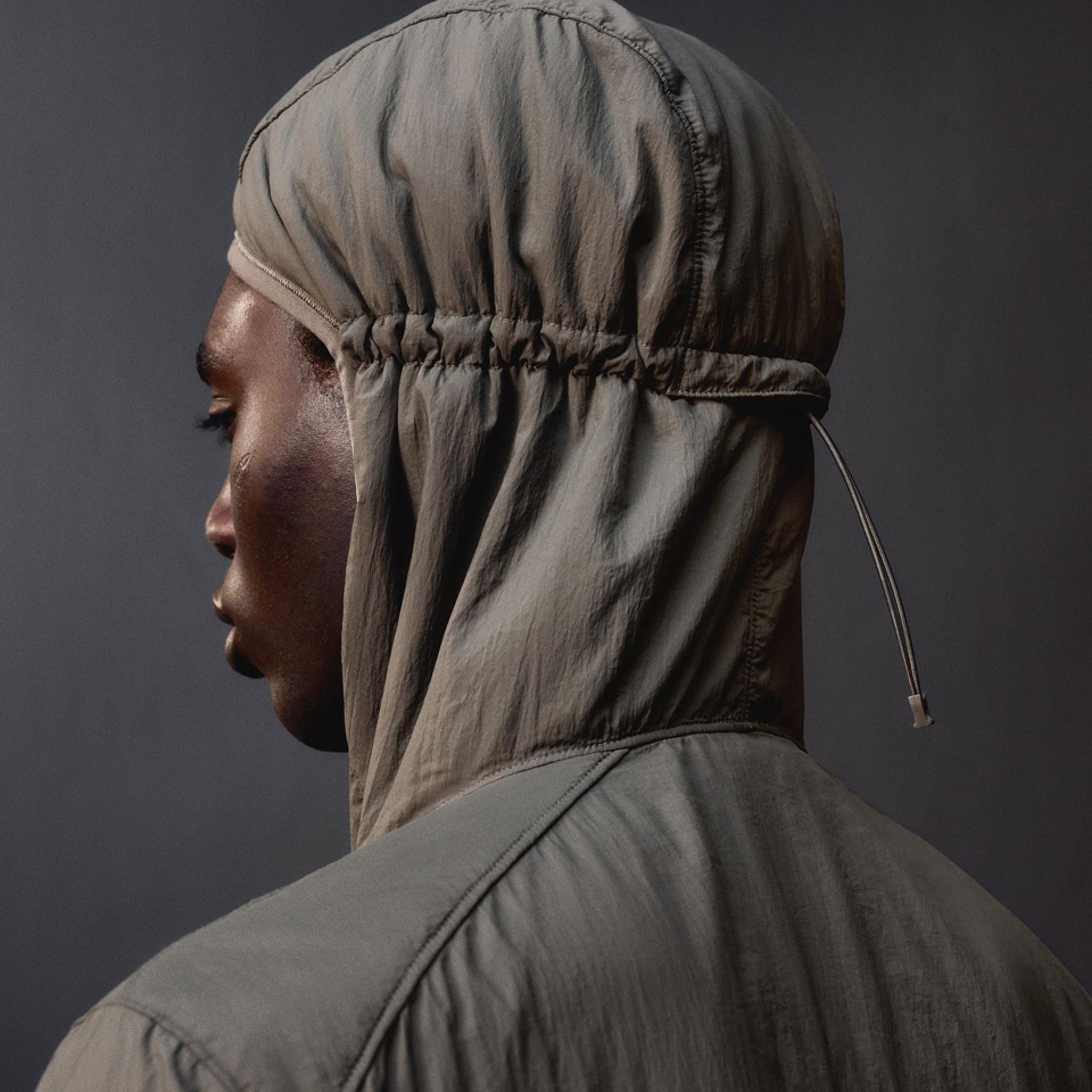 A close-up of a person wearing the InsulEight Cold Weather Run Shell with a focus on the hood that features an adjustable drawcord.