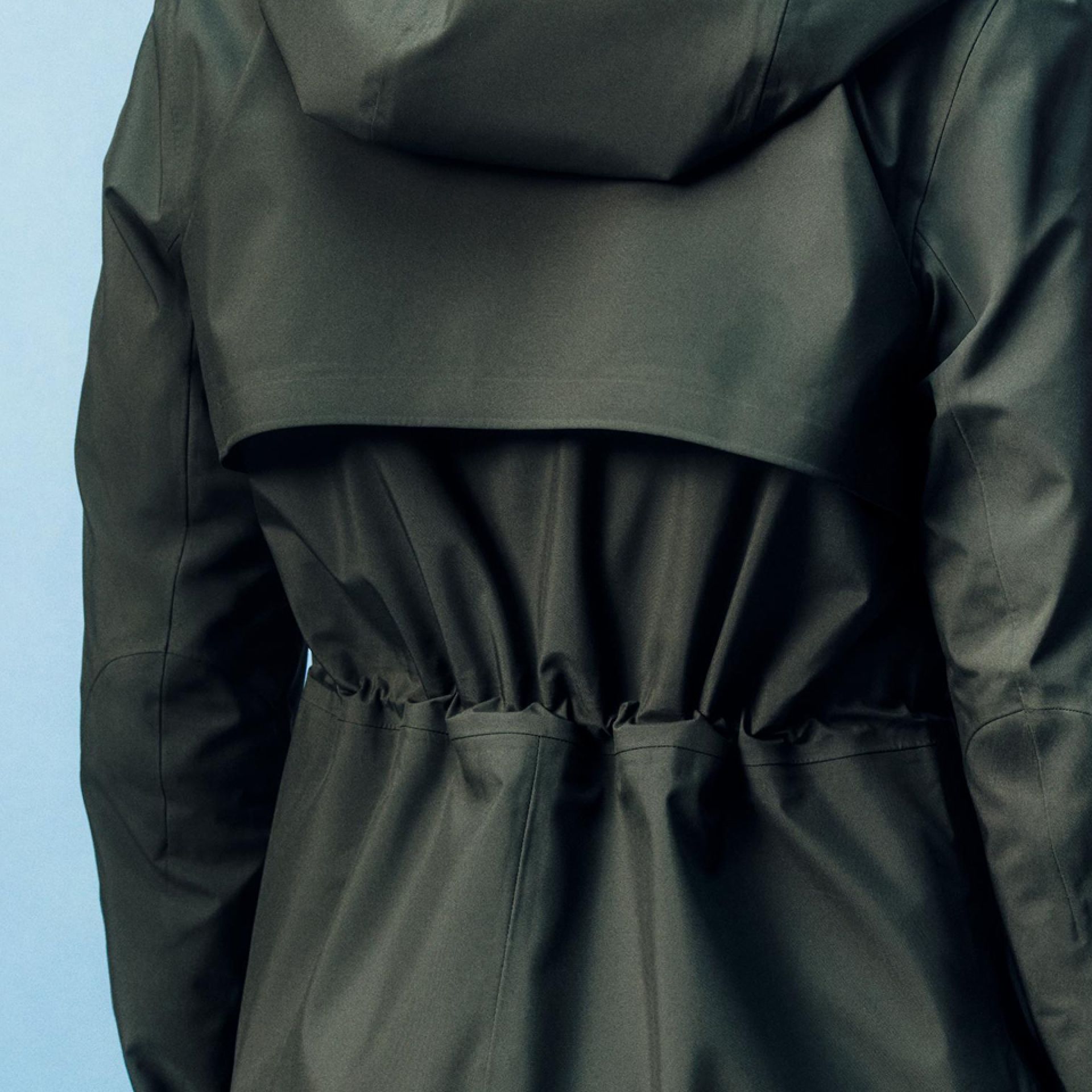 A close-up of a person wearing the Rain Rebel Jacket with a focus on the cinched in waist.