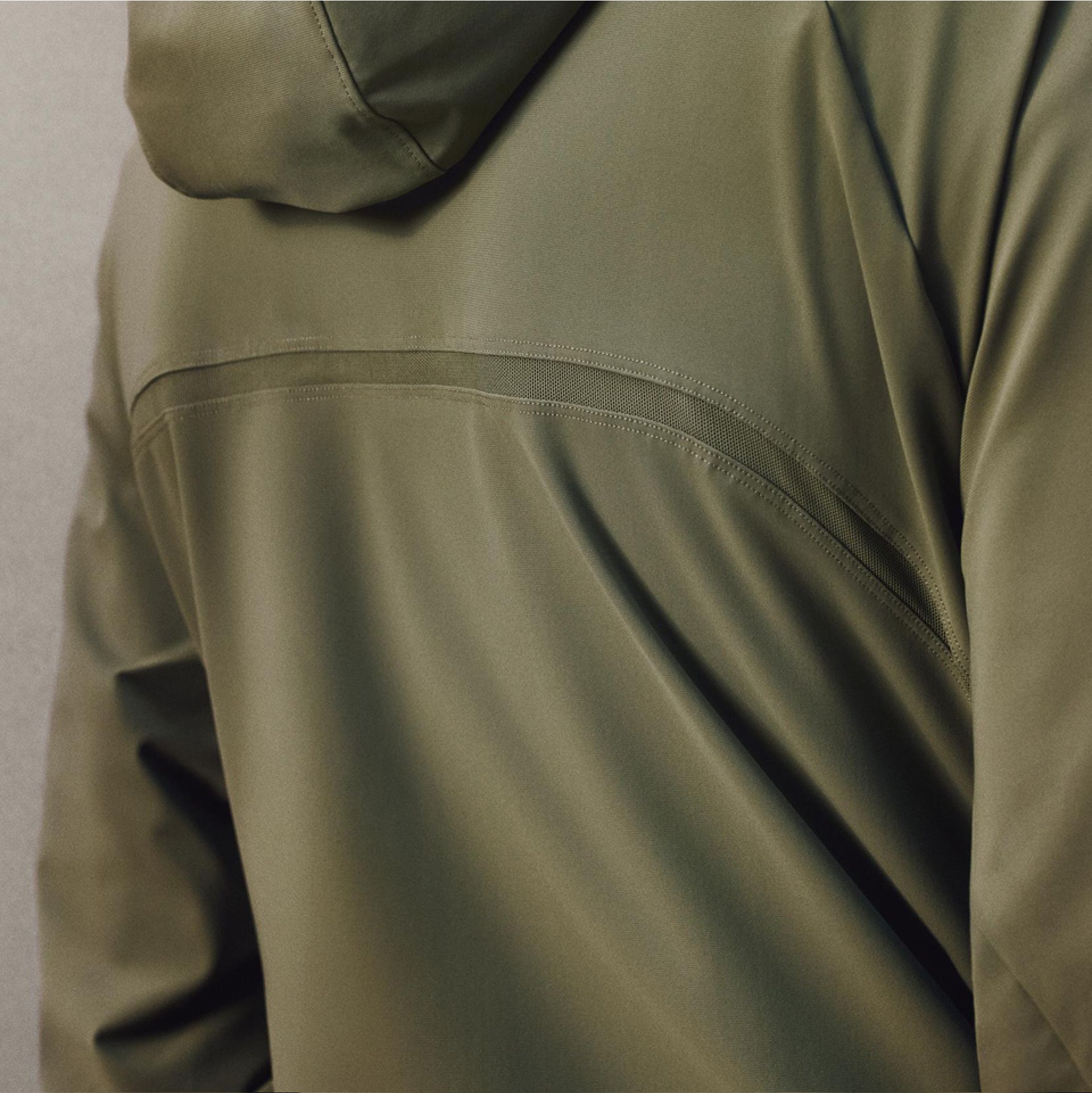 A close-up of a person wearing the Pace Breaker Jacket turned to show the back mesh ventilation.