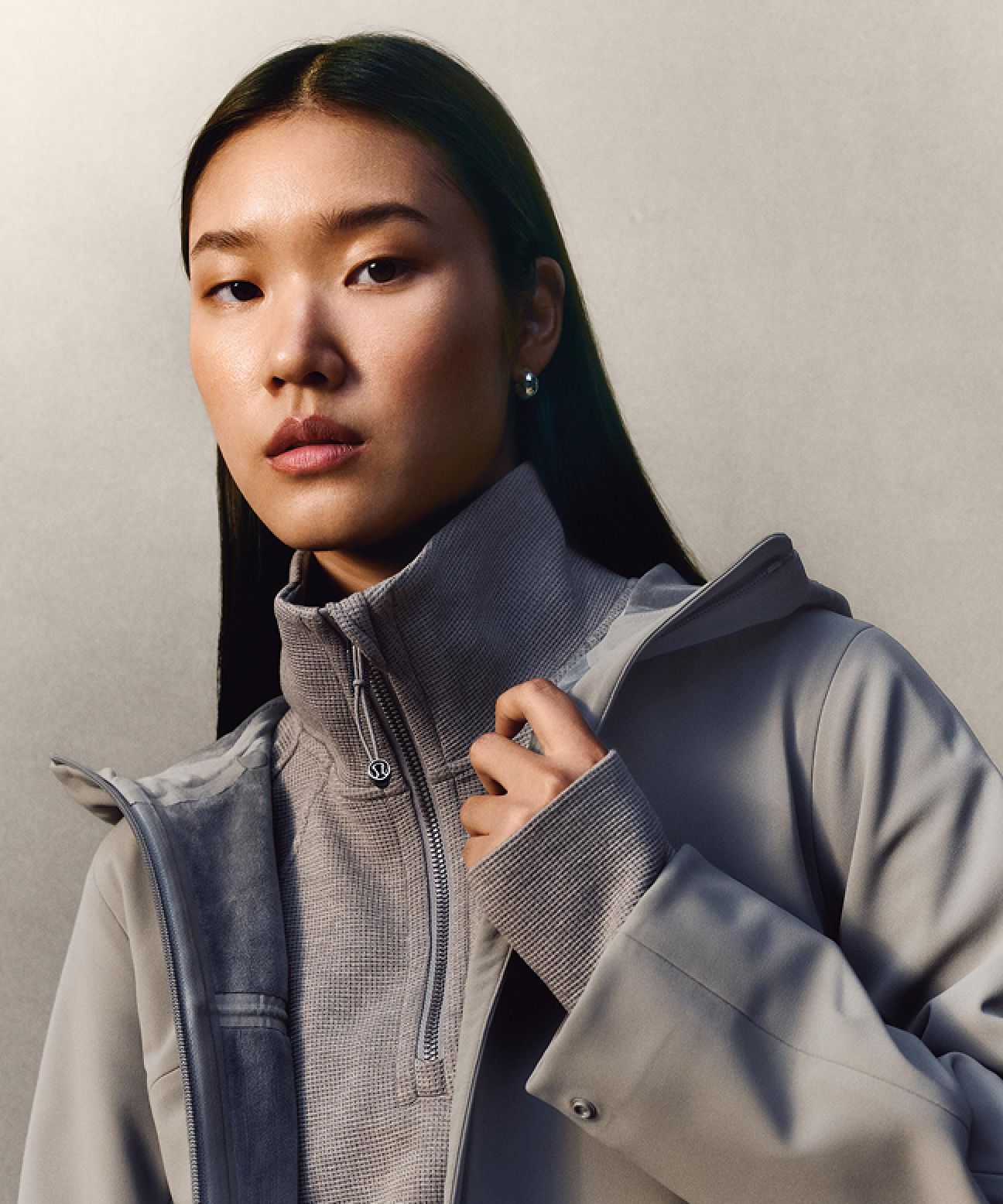 A person wearing the Cross Chill City-to-Trail Jacket with the Scuba Cropped Funnel-Neck Half Zip Waffle layered underneath while staring straight at the camera.