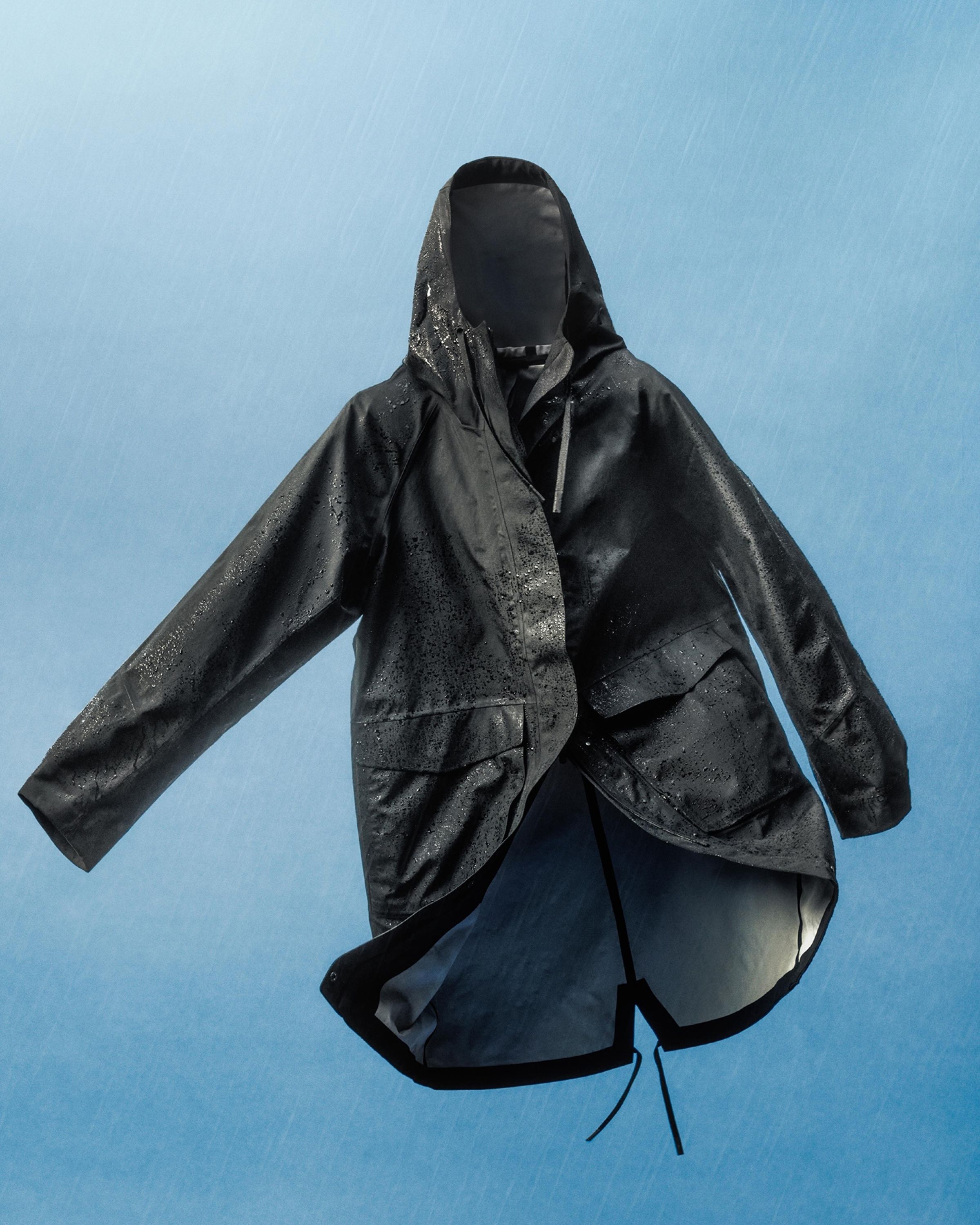 An image of the Fishtail Rain Coat floating with rain coming down around it.