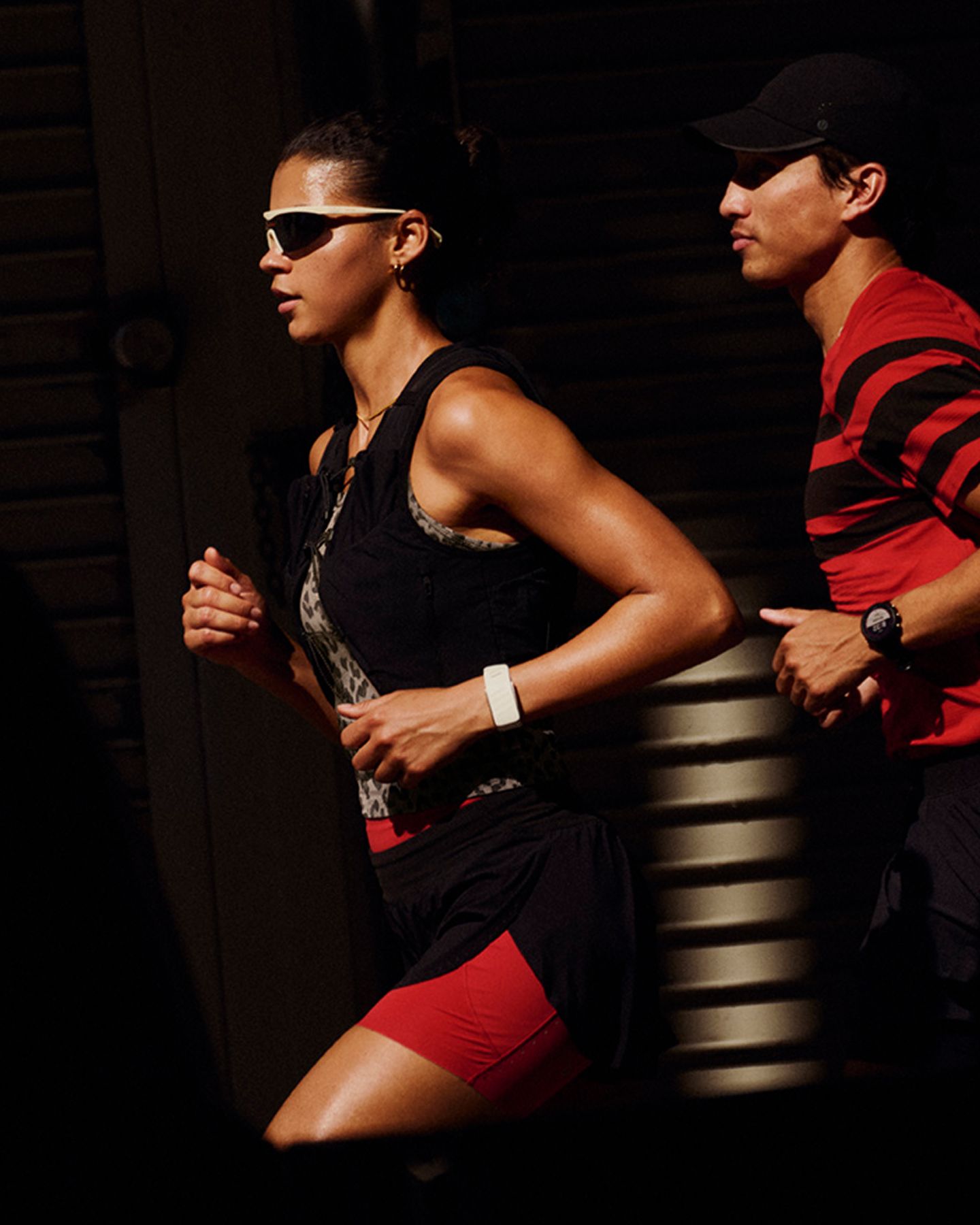 Ein Läufer und eine Läuferin in lululemon Kleidung joggen durch eine urbane Umgebung.