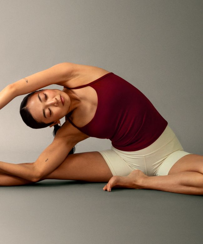 Eine Person beim Yoga, die das Flow Y Tanktop in der Farbe Cranberry Charm und die lululemon Align Shorts in der Farbe Light Ivory trägt.