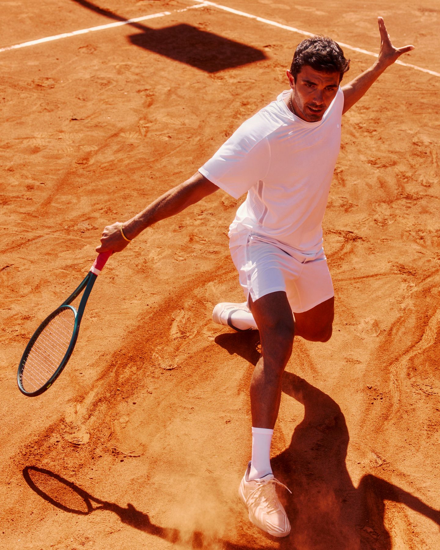 Eine Person spielt Tennis und trägt das Tennisshirt mit Mesheinsätzen und Shorts.