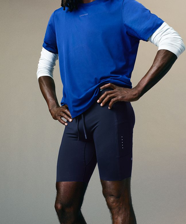 A person wearing a Fast and Free Short-Sleeve Shirt in Beach Ball Blue and the Fast and Free Half Tight 8” in True Navy.