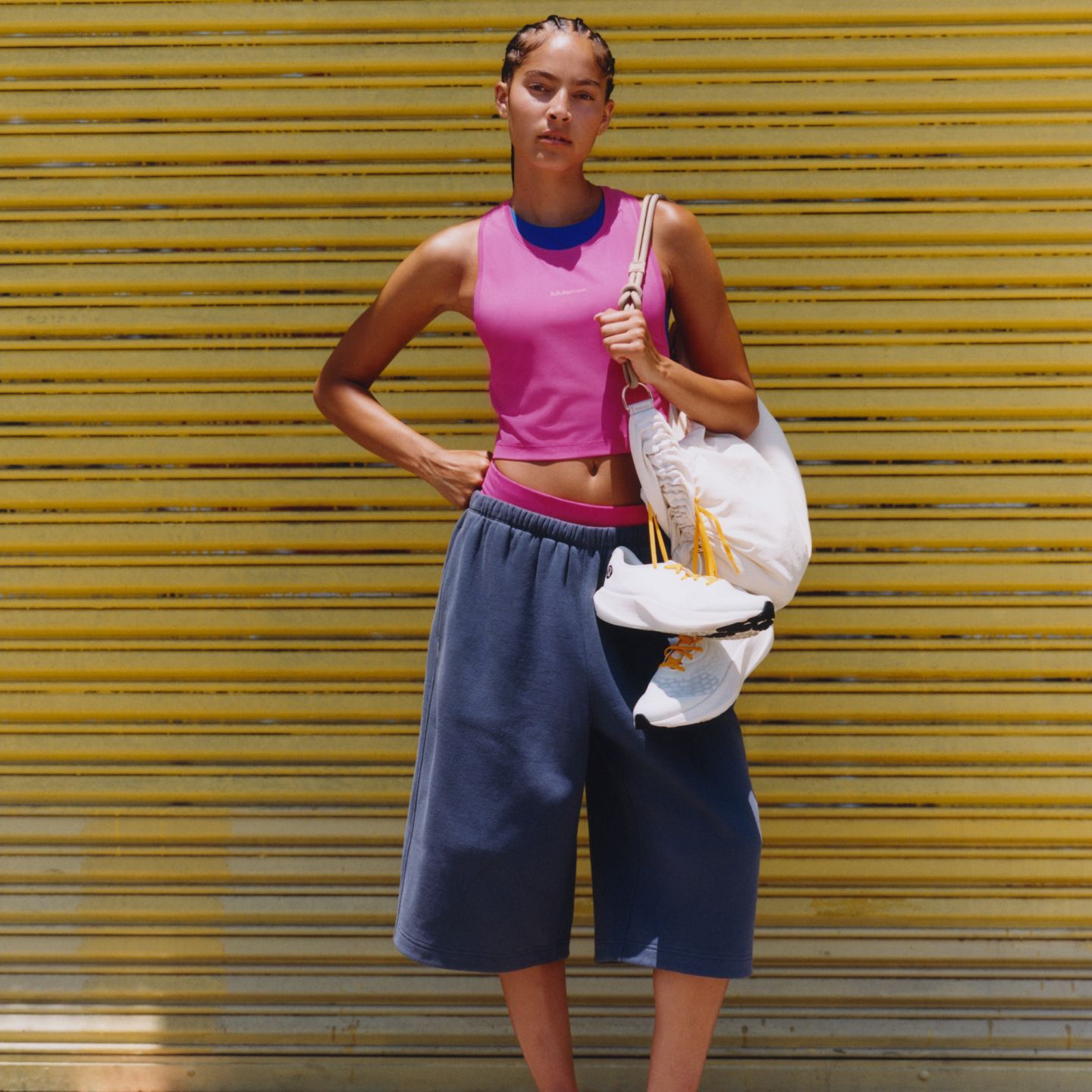 Eine Person trägt das Fast and Free-Singlet in Race-Länge in einem Rosaton und die Steady State-Oversized-Shorts aus Superloft mit einer Innenbeinlänge von 38 cm in einem Blaugrauton.