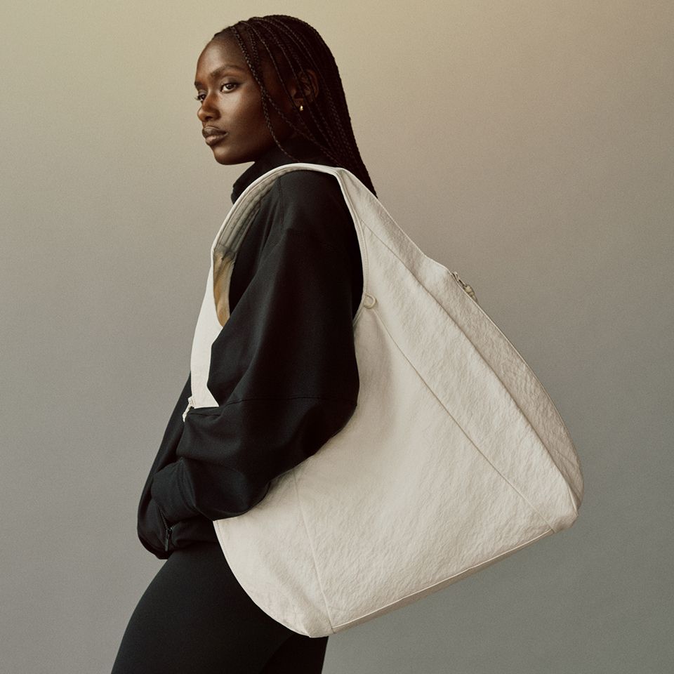 Eine Person mit einer Schultertasche von lululemon.