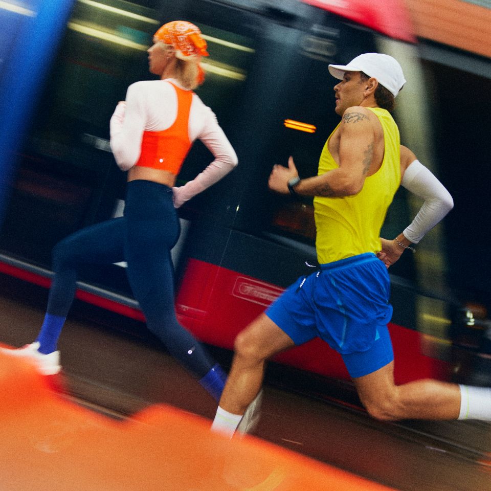 Right: first athlete wears Running Top in Orange Punch, Fast and Free Six-Pocket Tight in True Navy. Second Athlete wears men’s Fast and Free Tank in Lime Yours, Men’s Fast and Free Airflow Shorts in Disco Cobalt.