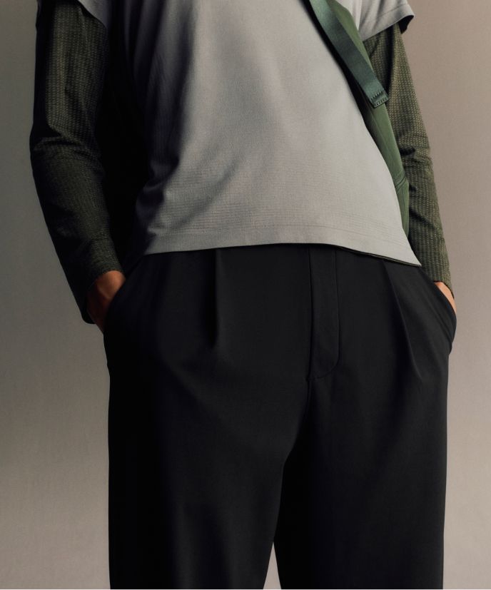 Eine Person trägt die Daydrift-Faltenhose im Relaxed Fit in Schwarz, das Metal Vent Tech-Shirt mit kurzem Reißverschluss in Grau und darüber das ärmellose Metal Vent Tech-Shirt in Grau.