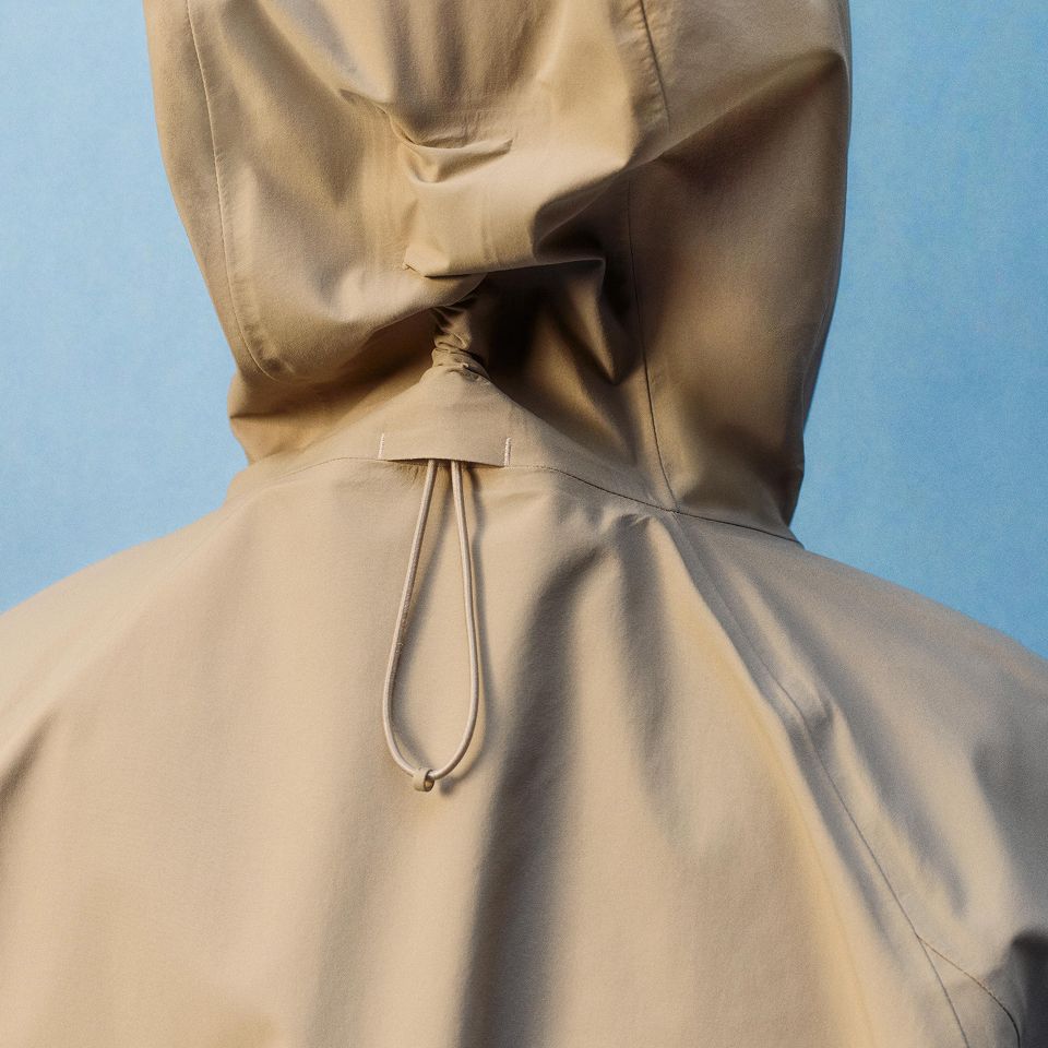 A person wearing the Rain Rebel Waterproof Jacket in Oakwood Tan.