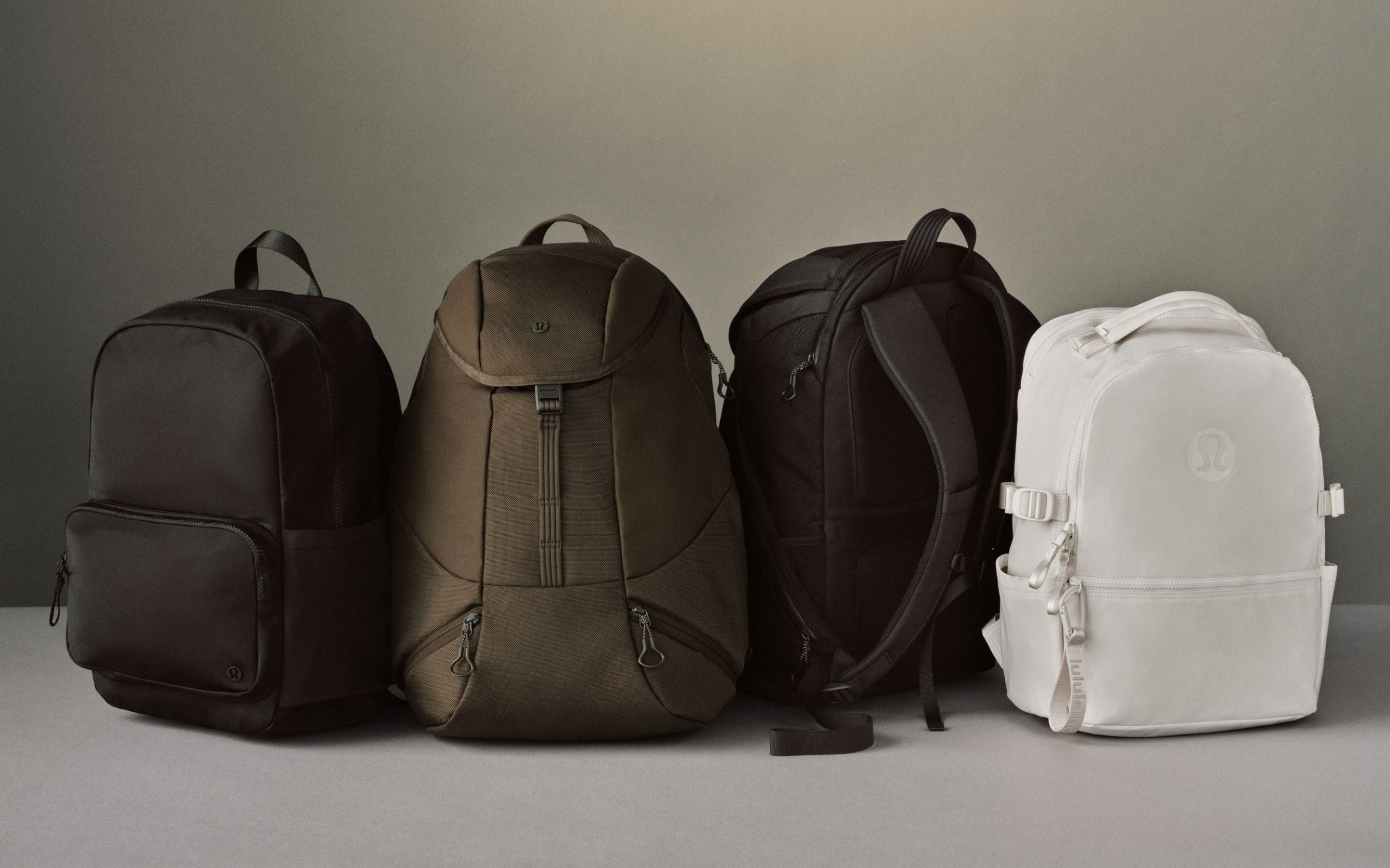 Four backpacks are shown sitting next to eachother: Everywhere Backpack, Daily Dispatch Backpacks. and New Crew Backpack.