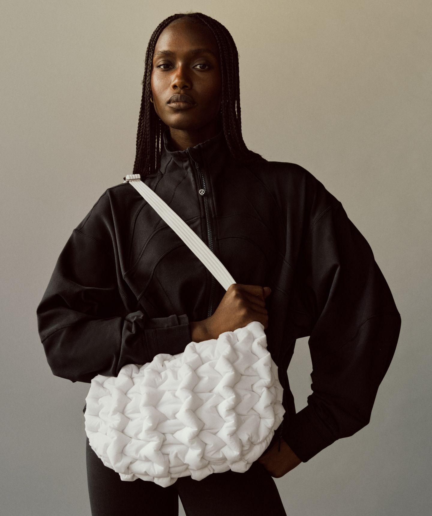 A person stands with the Quality Puff Crossbody on their shoulder.