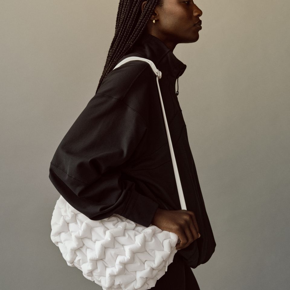 A person with the Quality Puff Crossbody on their shoulder.