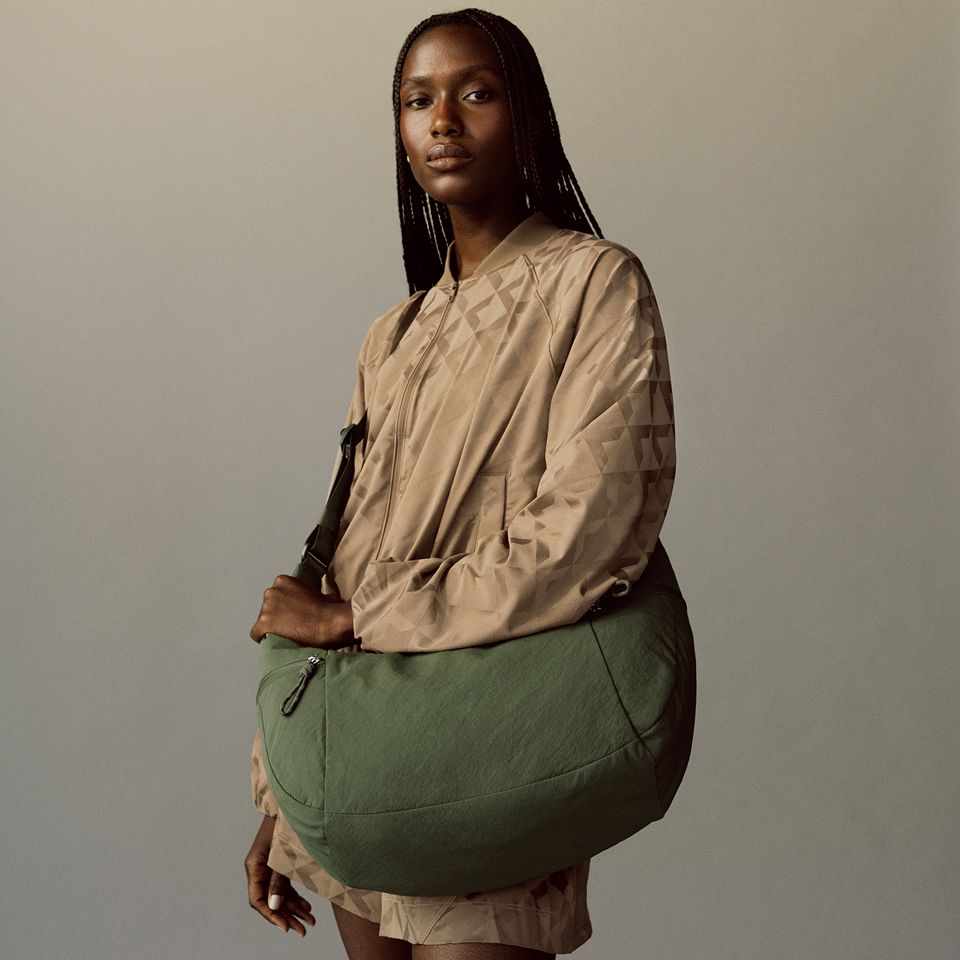 A person is standing with the Slouchy Shoulder Bag on their shoulder.