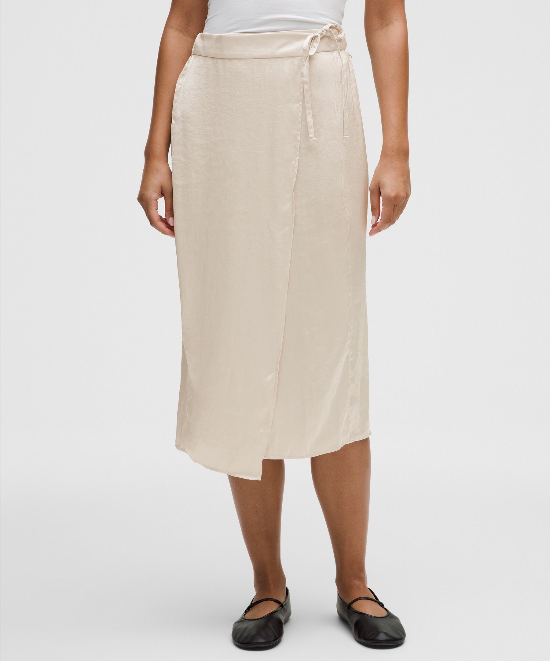 Jupe mi-longue en satin attachée à la taille avec perle à logo
