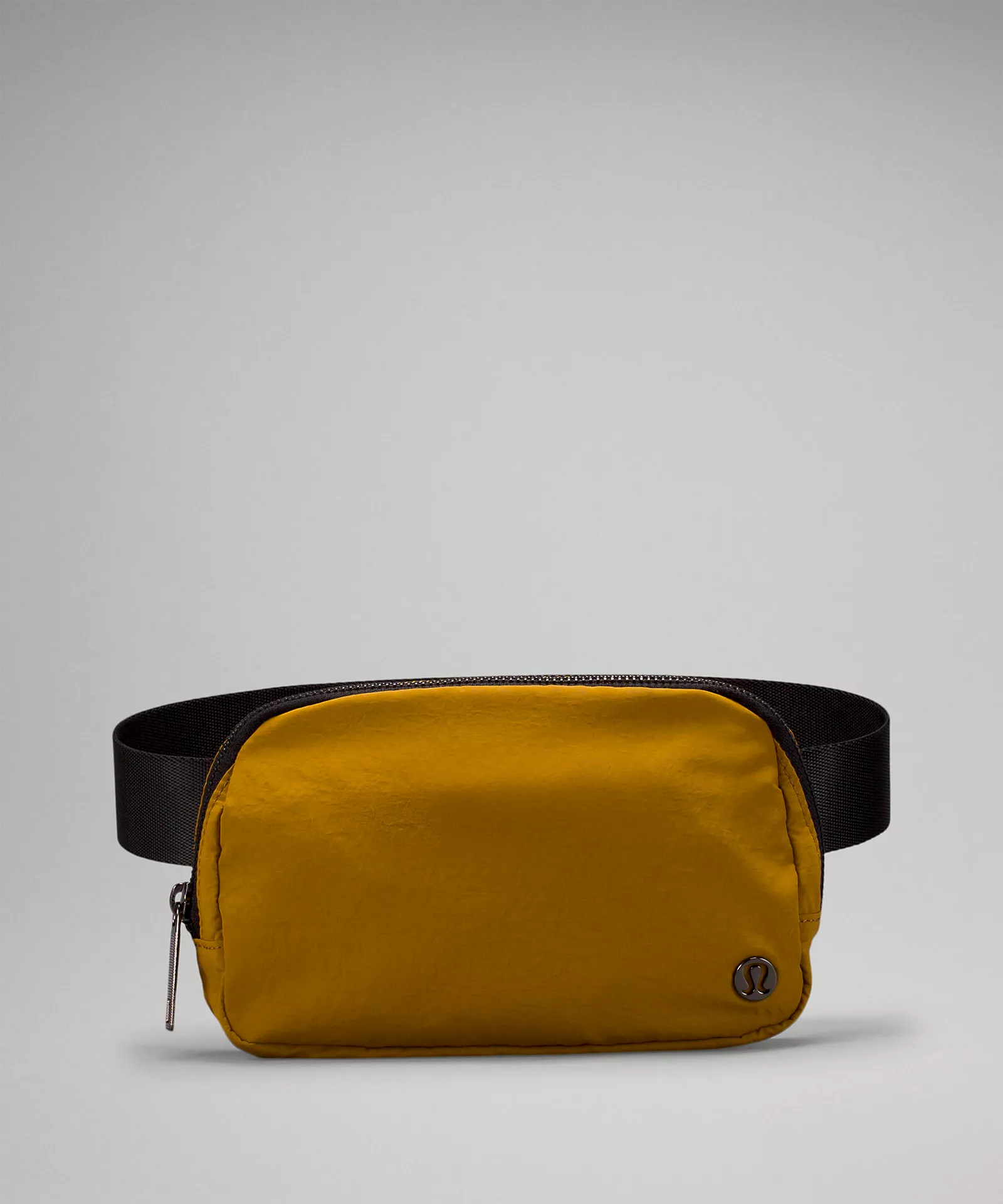 Mustard yellow belt bag with a black strap.
