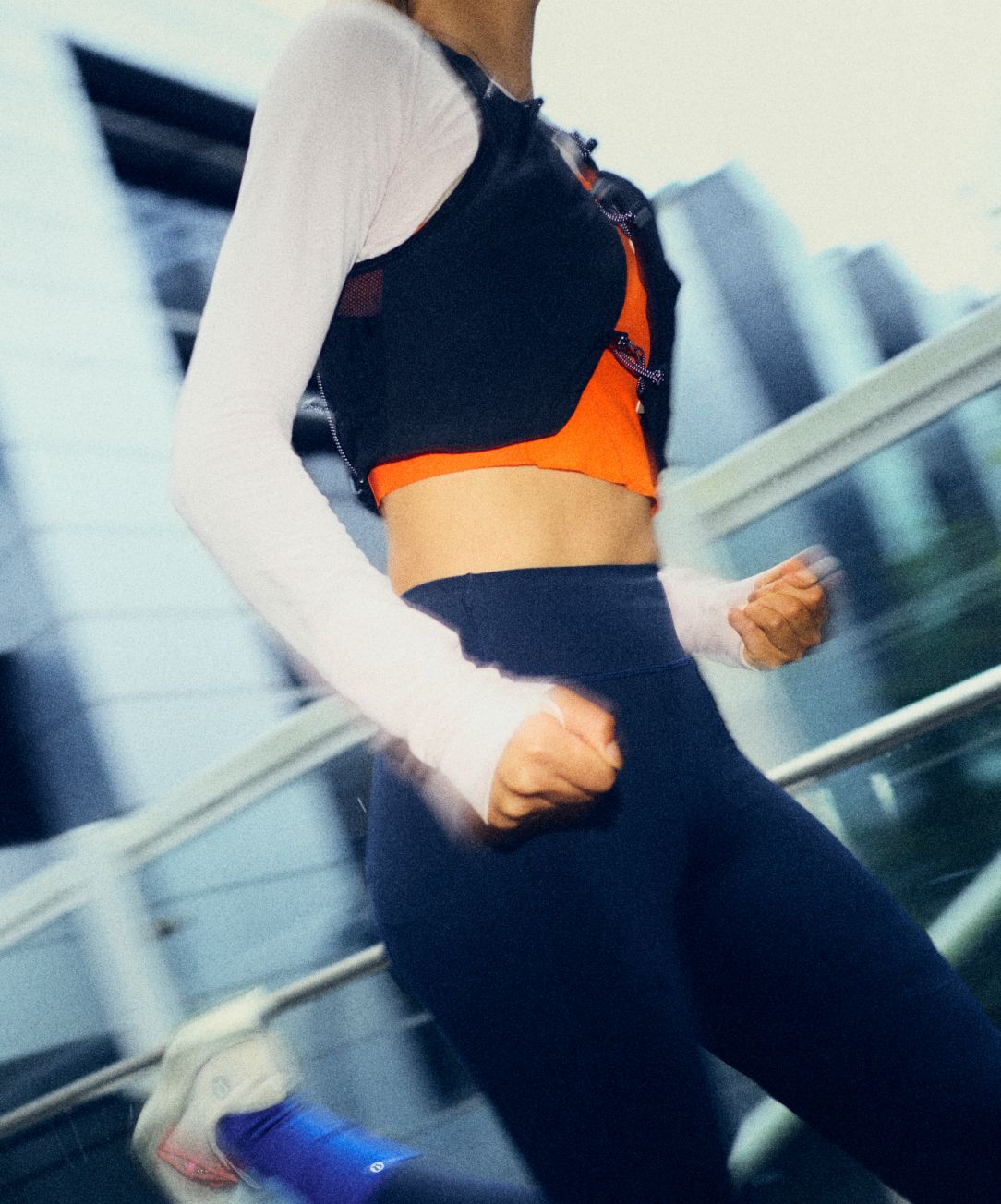A person wears the lululemon Fast and Free Trail Running Vest while running through the city. 