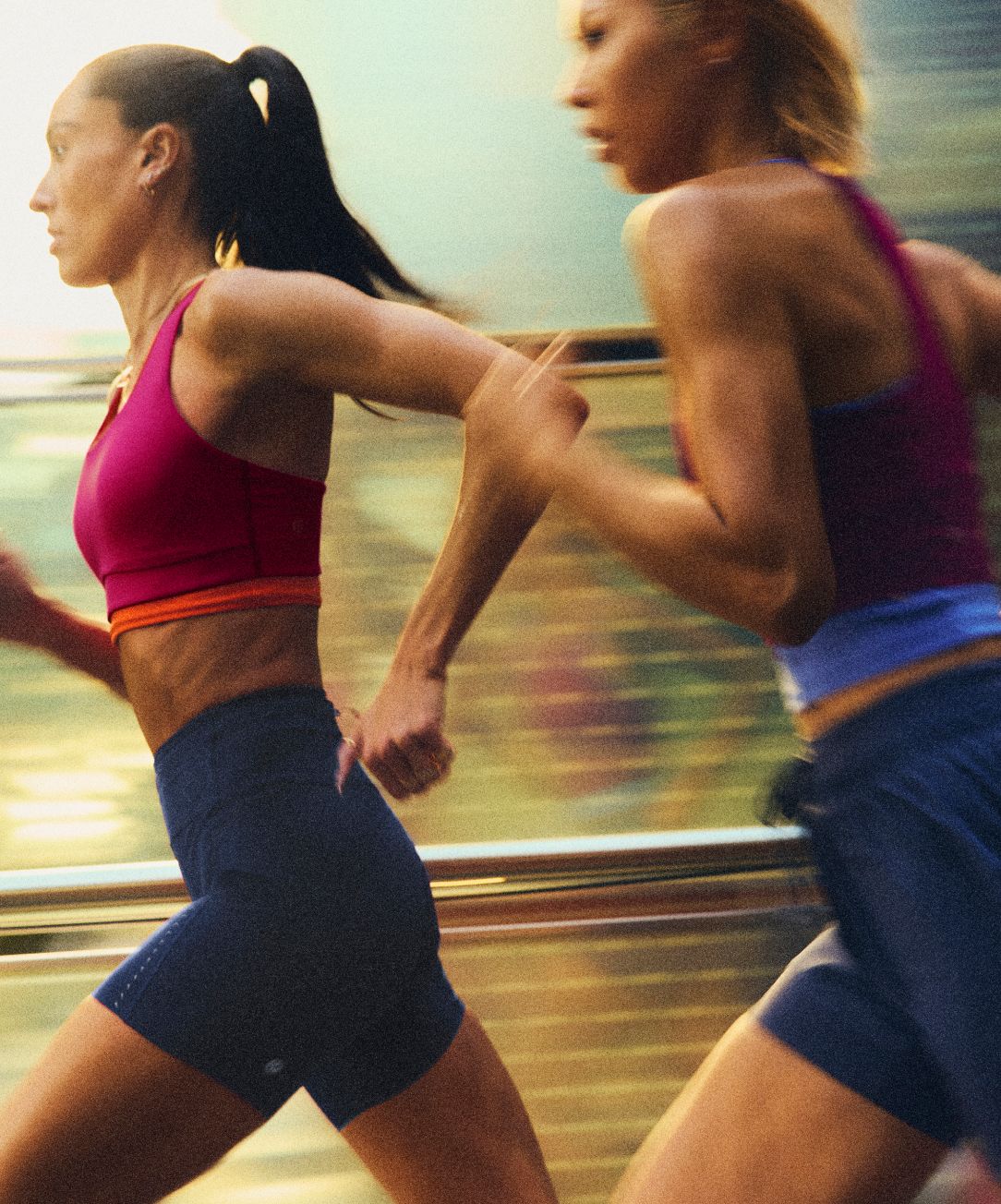 Two people wear lululemon Fast and Free™ running gear while running through the city. 