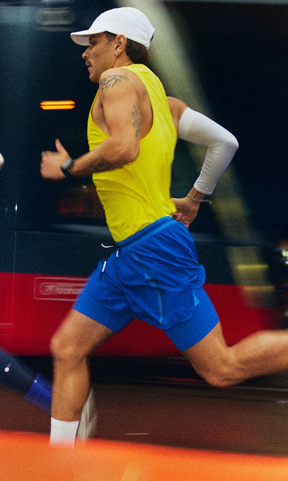 A person wears the Fast and Free Singlet and Fast and Free Era Shorts while running through the city. 