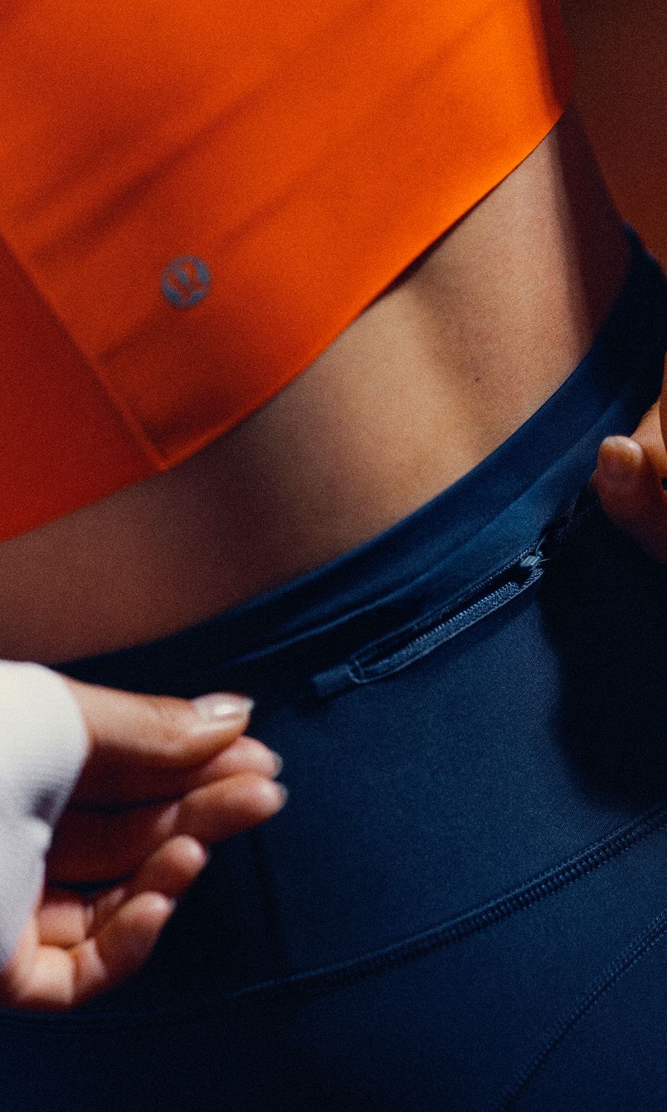 A person wears the lululemon Fast and Free™ High-Rise Tight, featuring a secure back zip pocket.  