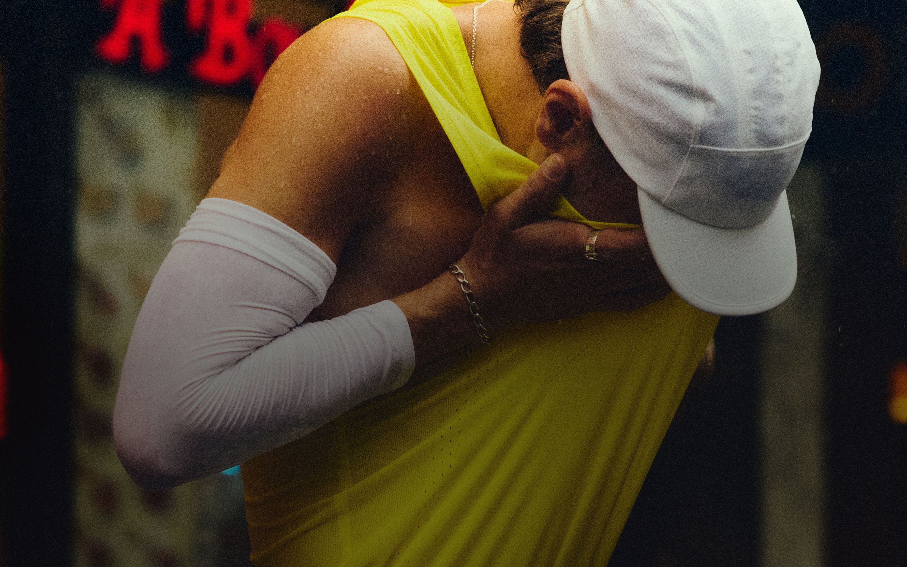 A person wipes sweat from their face with his shirt.