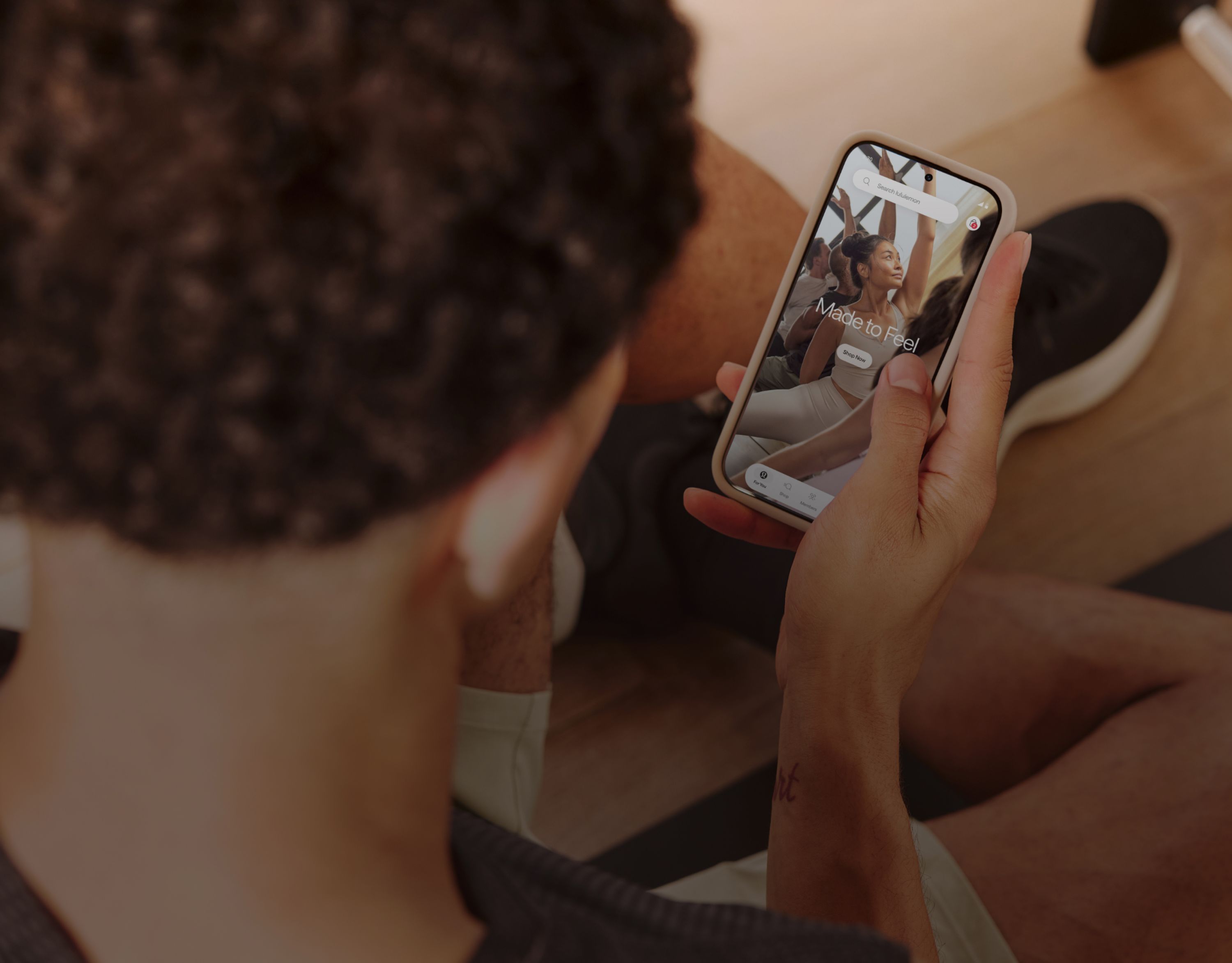 Close-up of a person looking at the lululemon app on an Android phone.