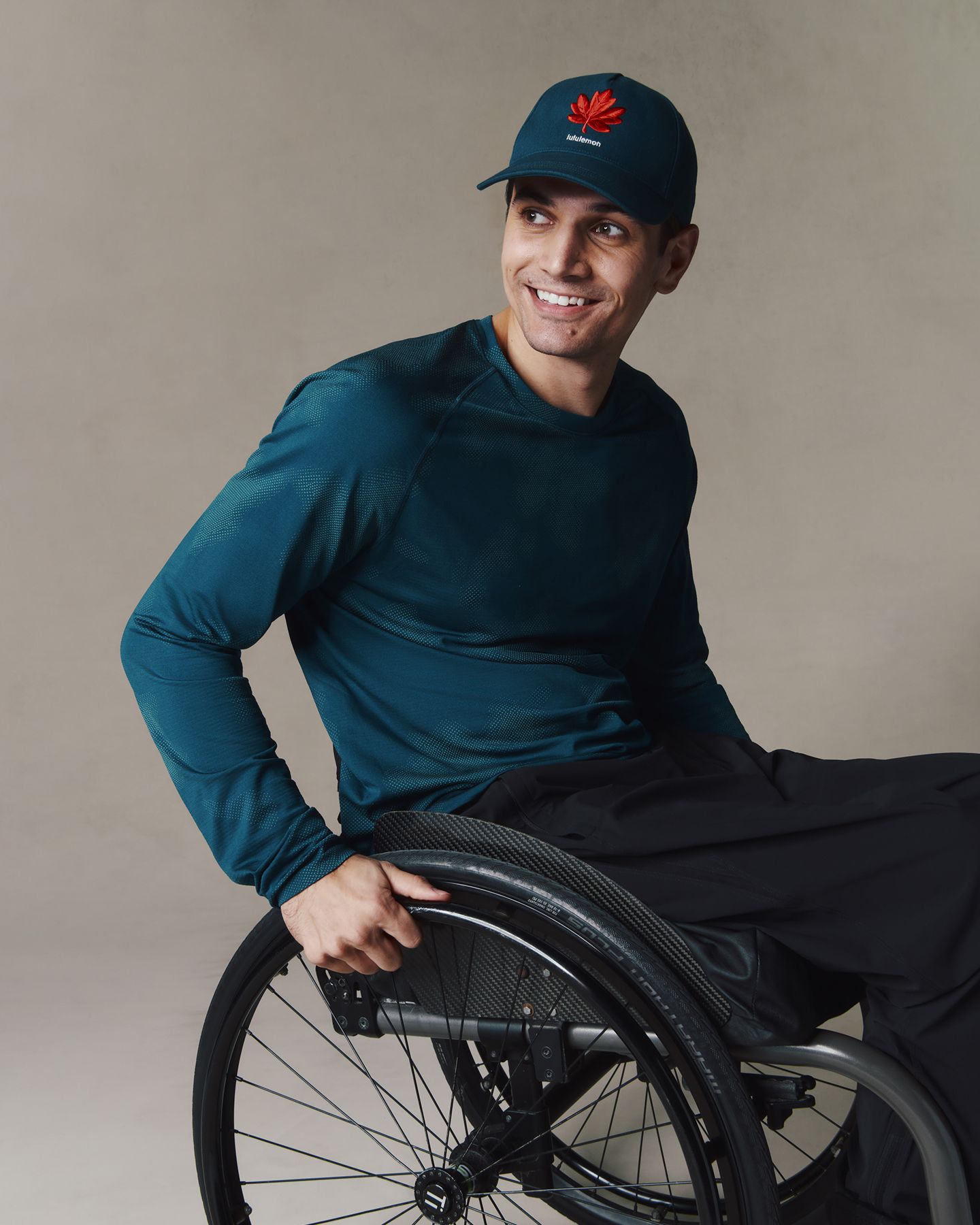 Un para-athlète en fauteuil roulant porte le chandail manches longues Metal Vent Tech Équipe Canada et la casquette classique Futur patrimoine. 