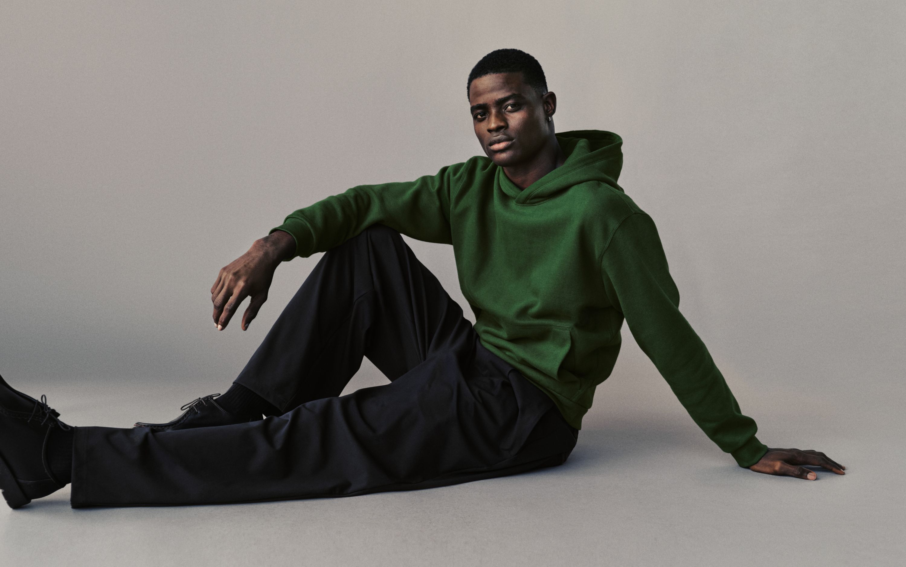 A person wears the Steady State Pullover Hoodie and Daydrift Relaxed Pleated Trouser. On image text reads: "Daydrift: tailored to move."