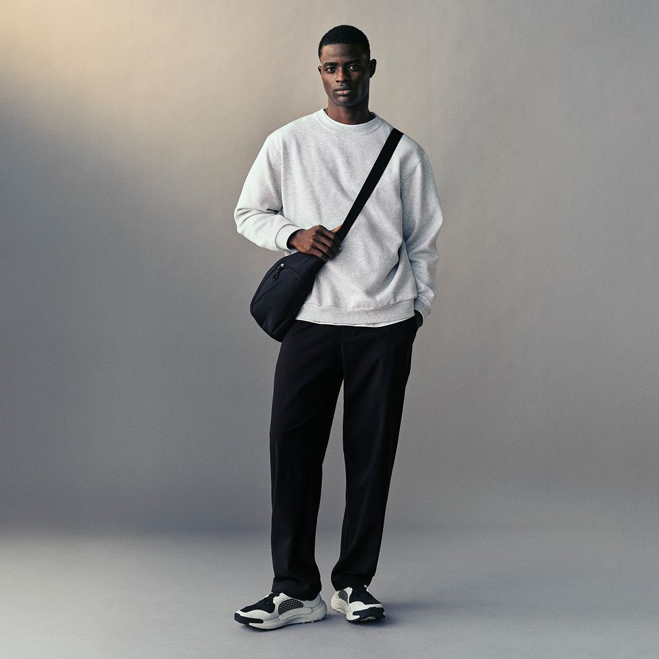 A person wears the Steady State Pullover Hoodie and Daydrift Relaxed Pleated Trouser.