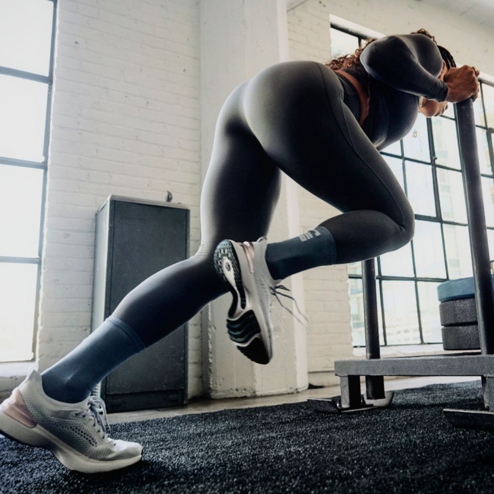 A person in lululemon clothes pushes a weight sled.