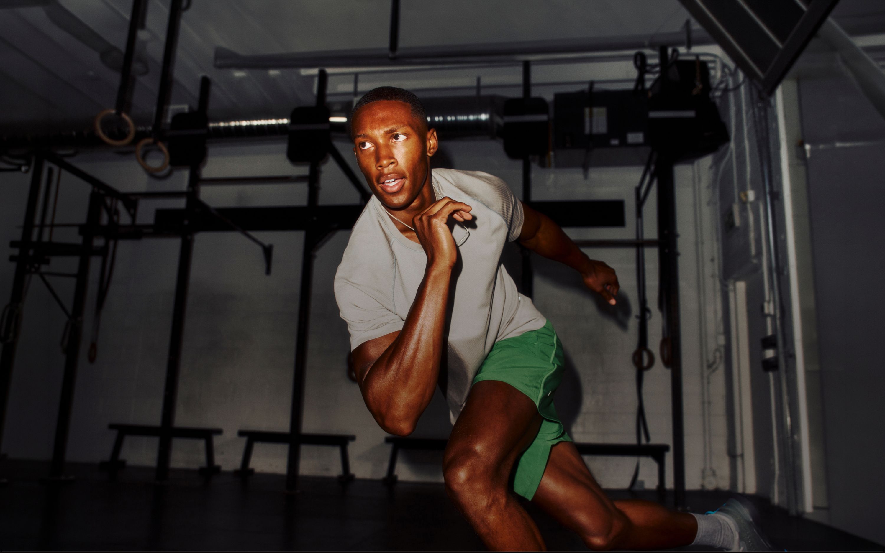 A person does skater jumps in a gym, wearing the Metal Vent Tech Shirt.