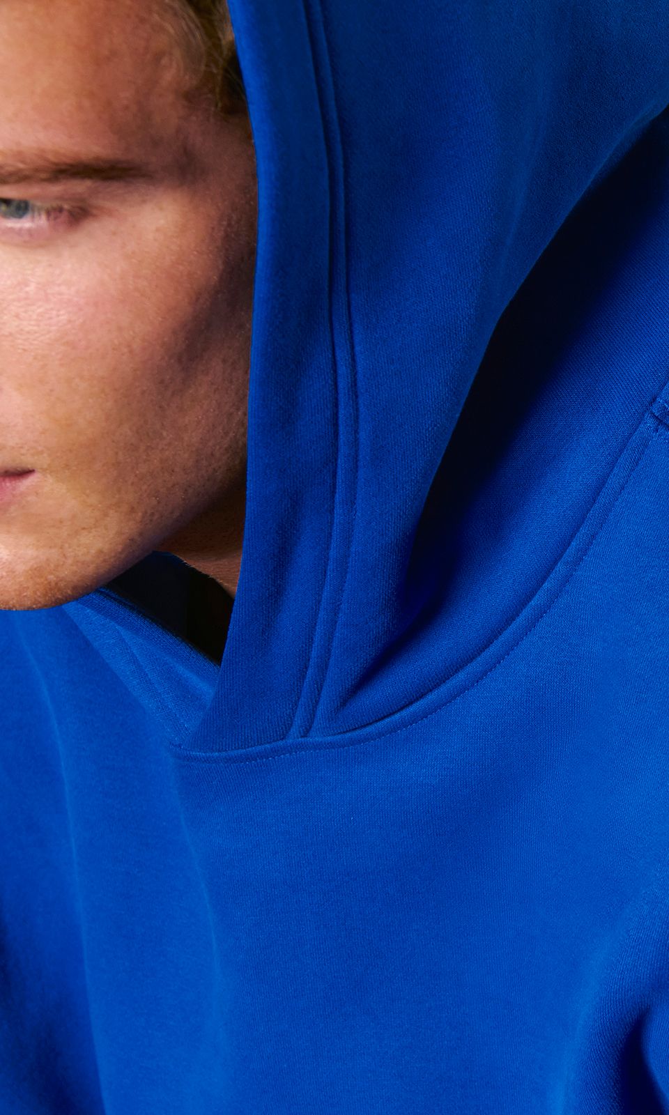 A person wears the new Steady State Pullover Hoodie in SuperLoft™ fleece. 