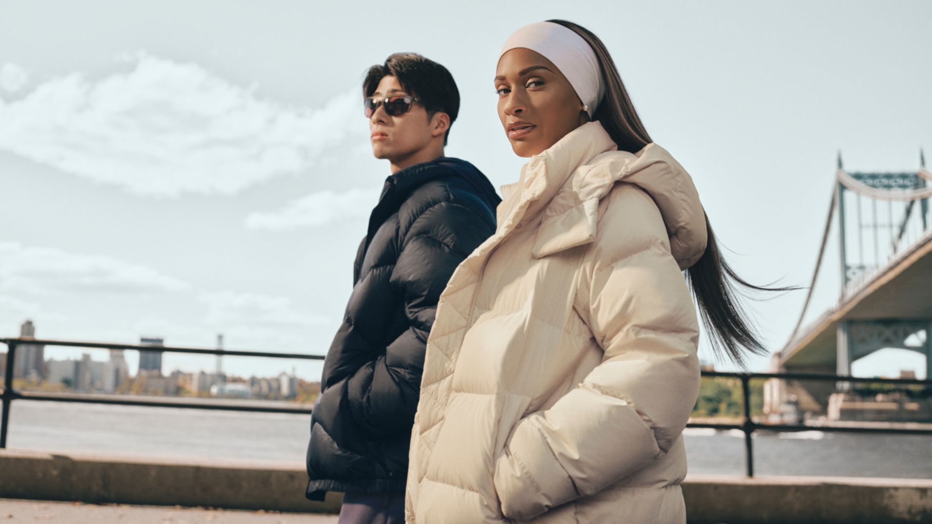 Two people walk along a promenade wearing a Wunder Puff and Featherweight jacket.