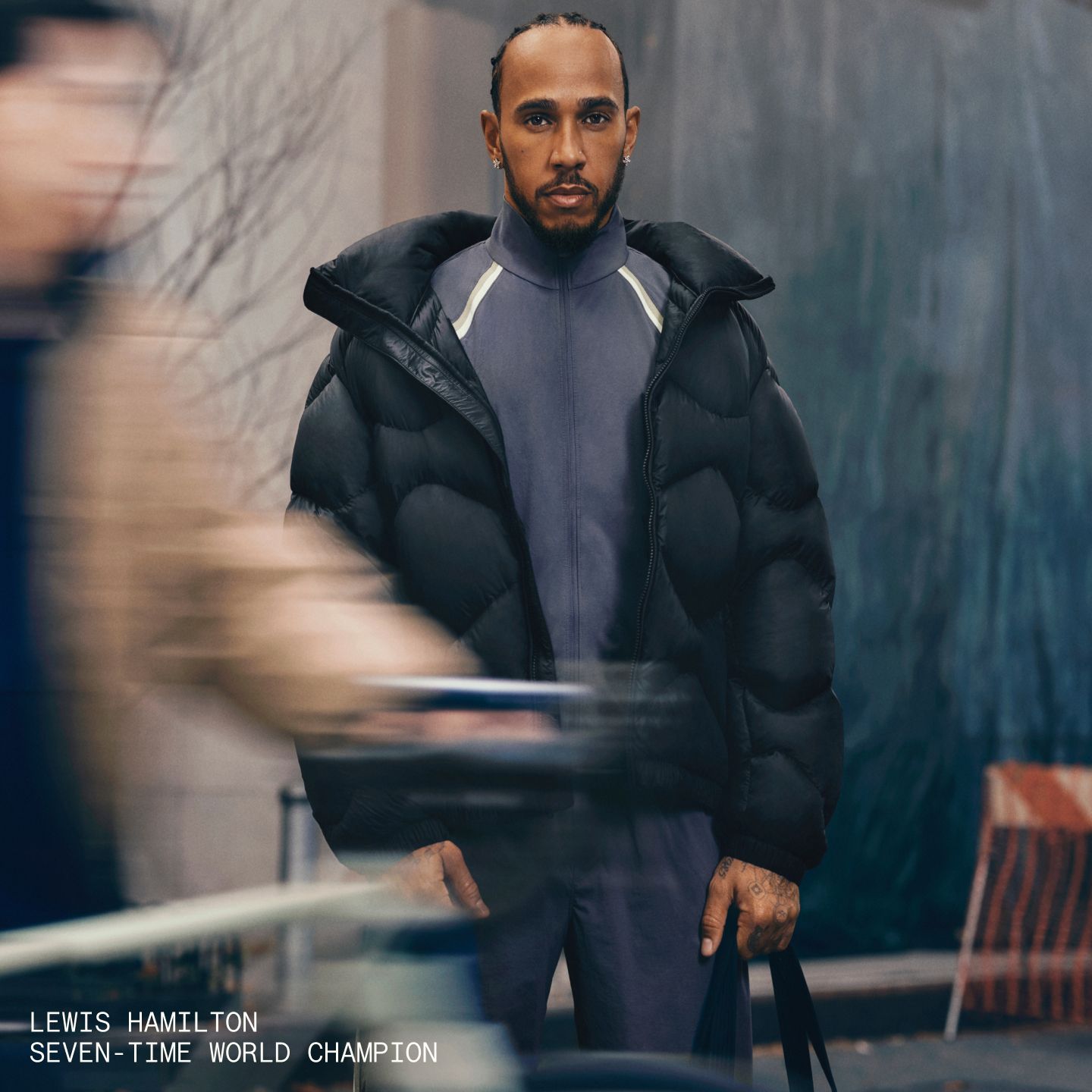 A person standing on a busy city street wearing a Featherweight jacket. 