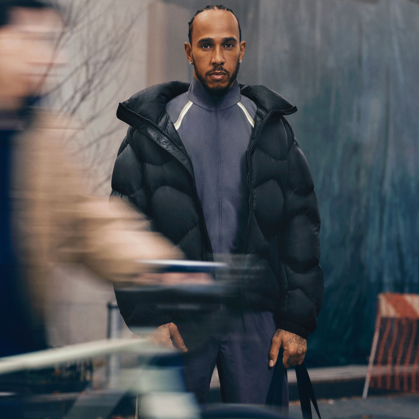 A person standing on a busy city street wearing a Featherweight jacket.