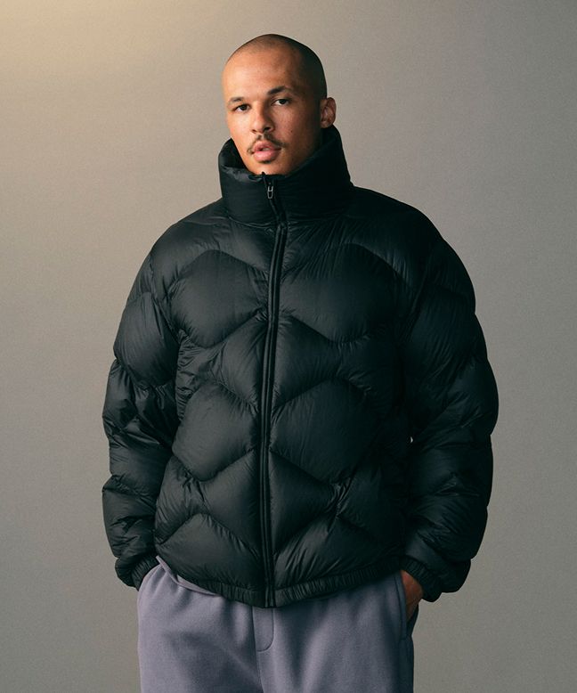 A person wearing a zipped-up Featherweight jacket. 
