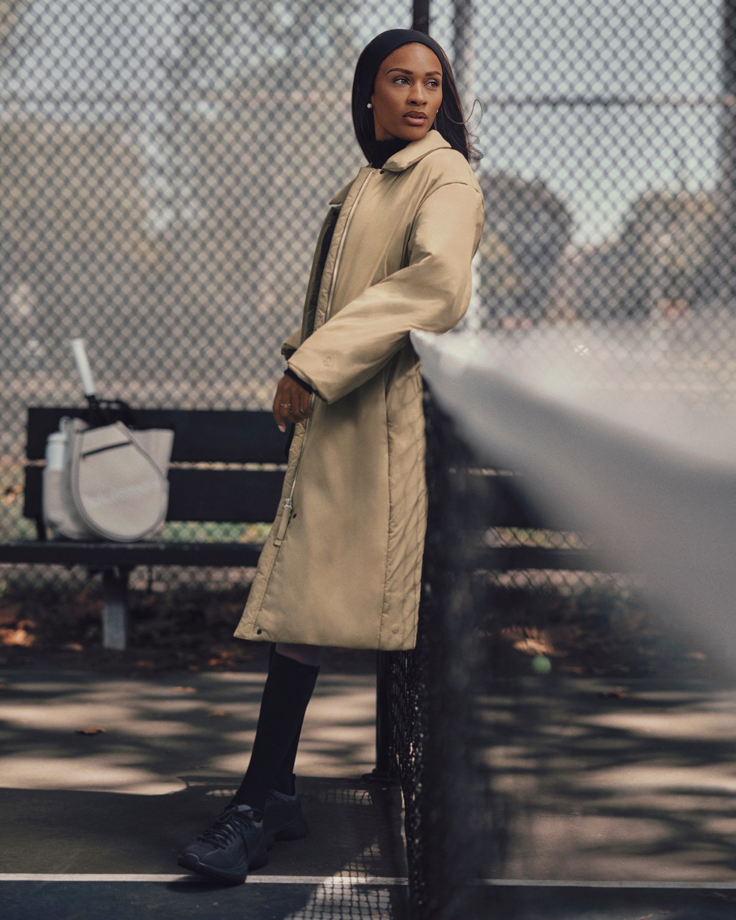A person standing on a tennis court wearing a ThermoZen jacket.