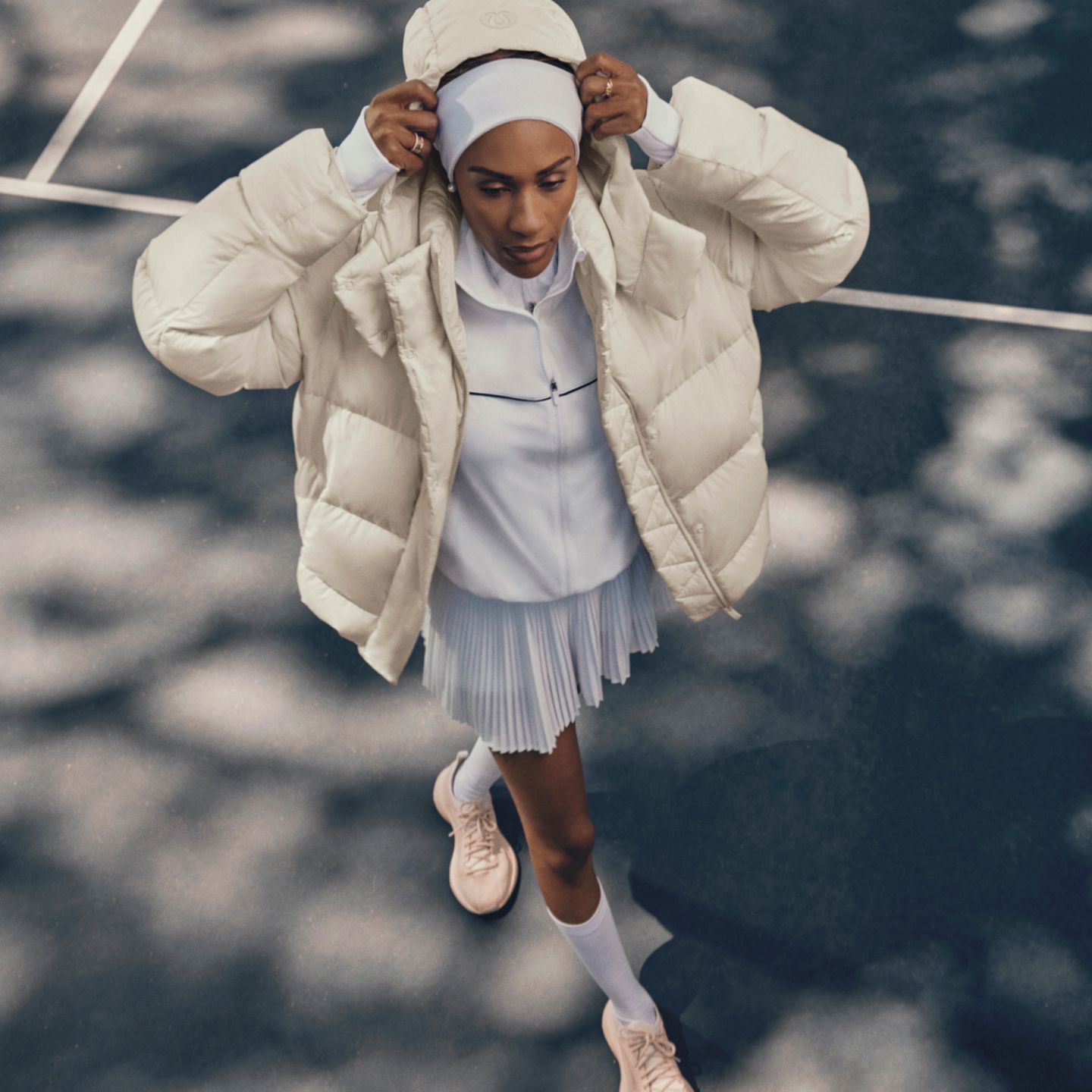 Une personne debout sur un terrain de tennis, portant un manteau Wunder Puff.