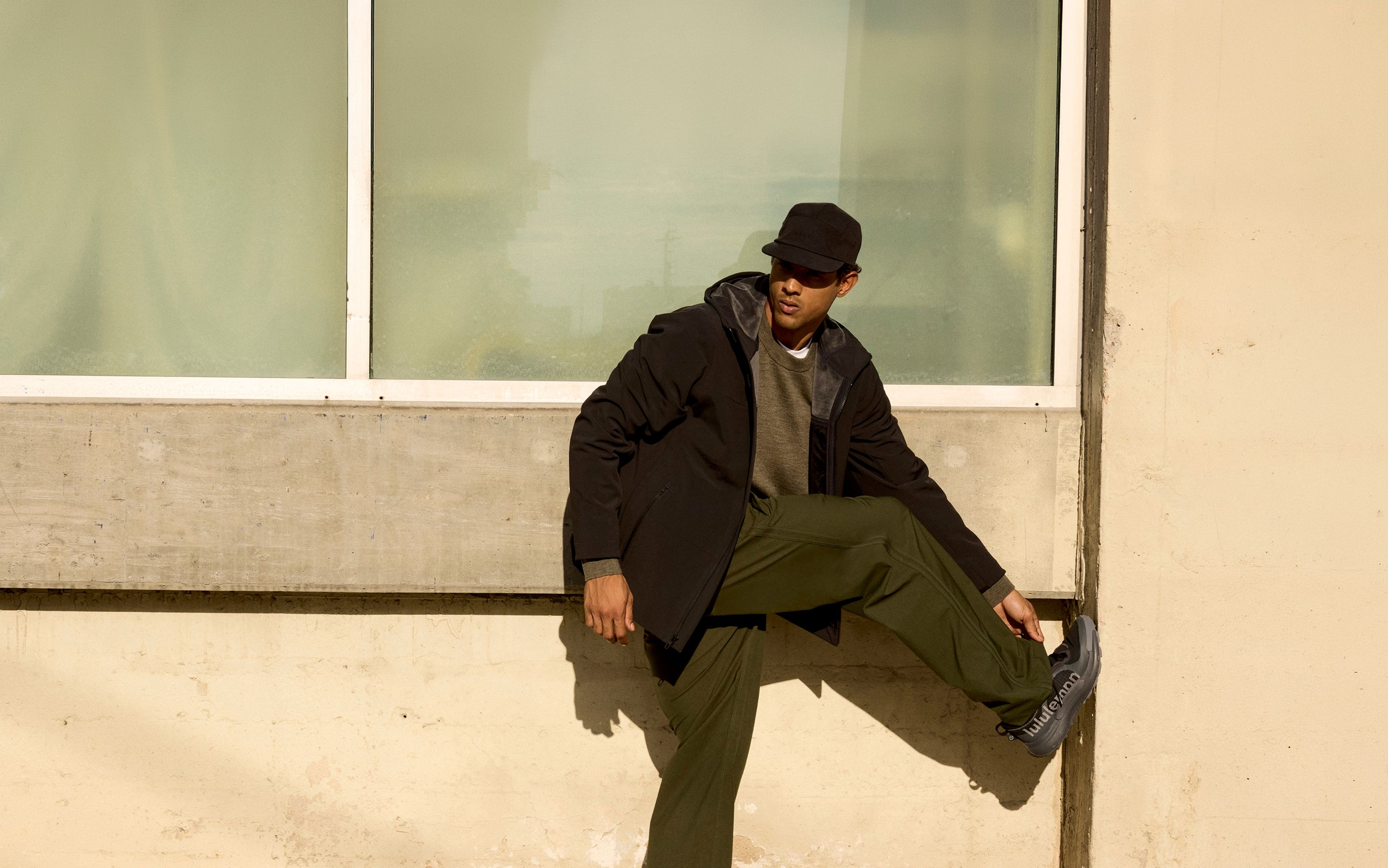 A person wears the lululemon Cross Chill City-to-Trail Jacket, Merino Wool Knit Sweater, and Smooth Twill Track Pant.
