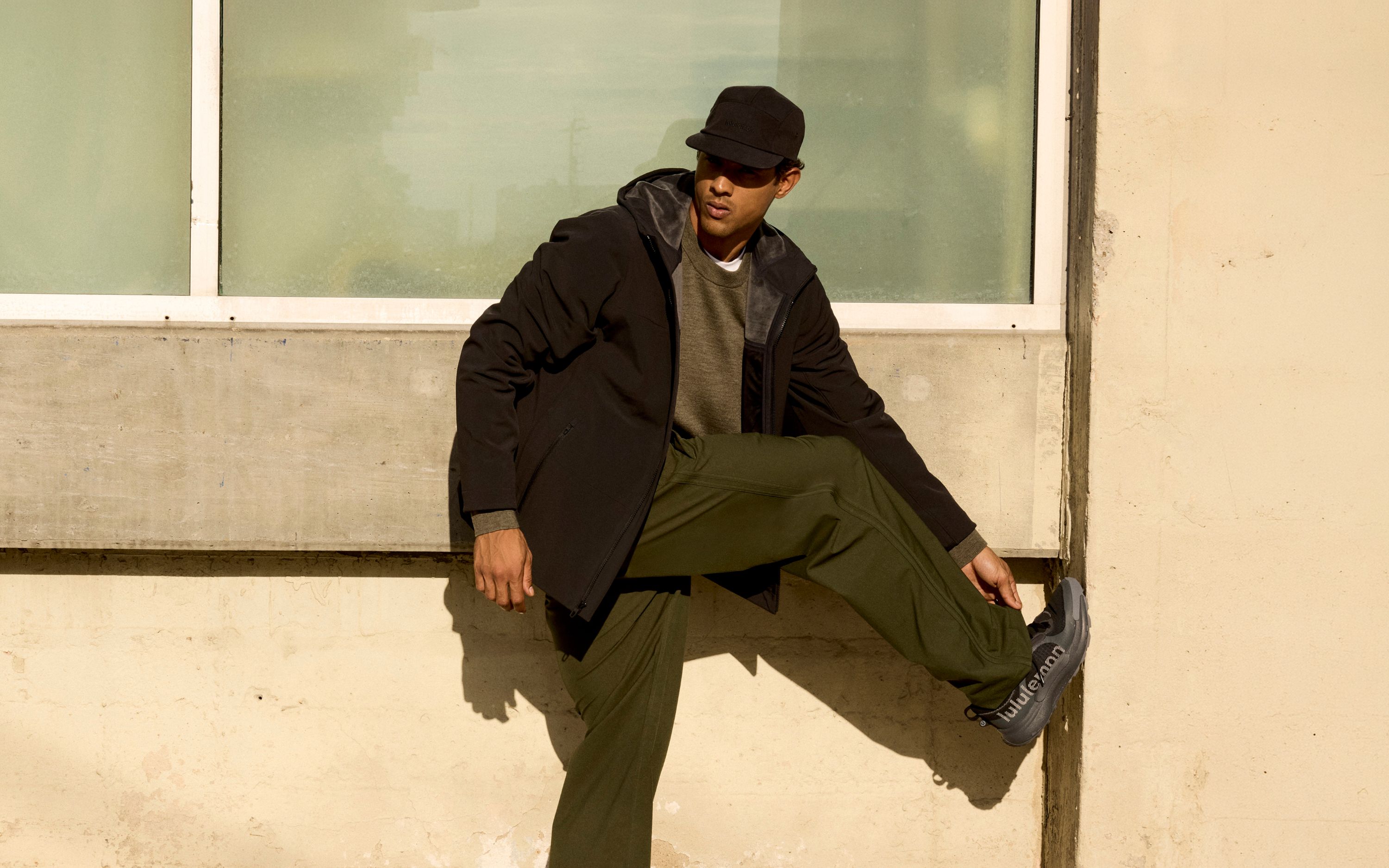 A person wears the lululemon Cross Chill City-to-Trail Jacket, Merino Wool Knit Sweater, and Smooth Twill Track Pant.