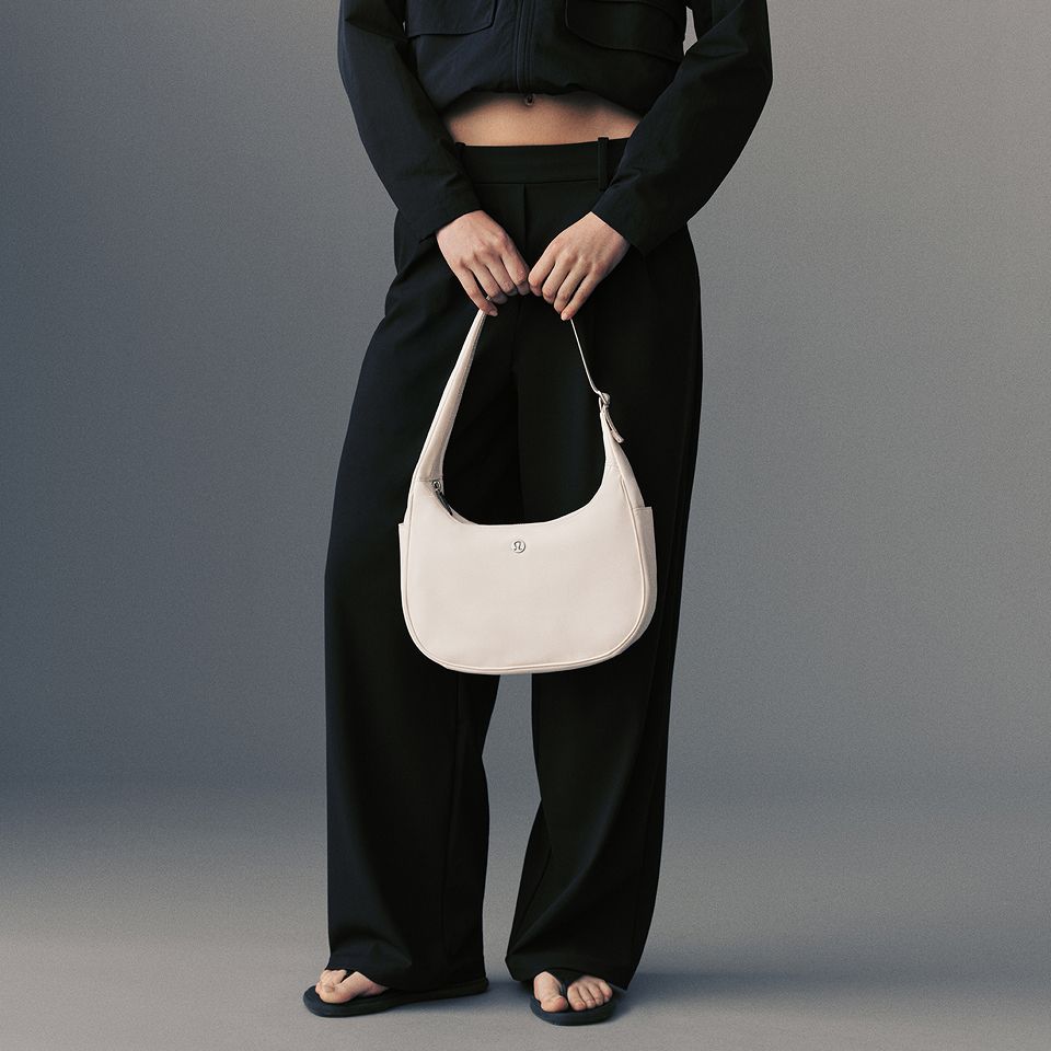A person holds the City Essentials Shoulder Bag.