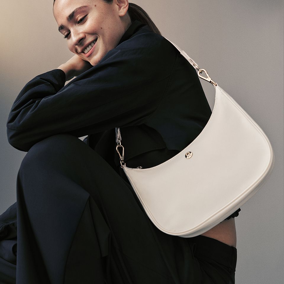 A person carries the City Essentials Small Shoulder Bag.