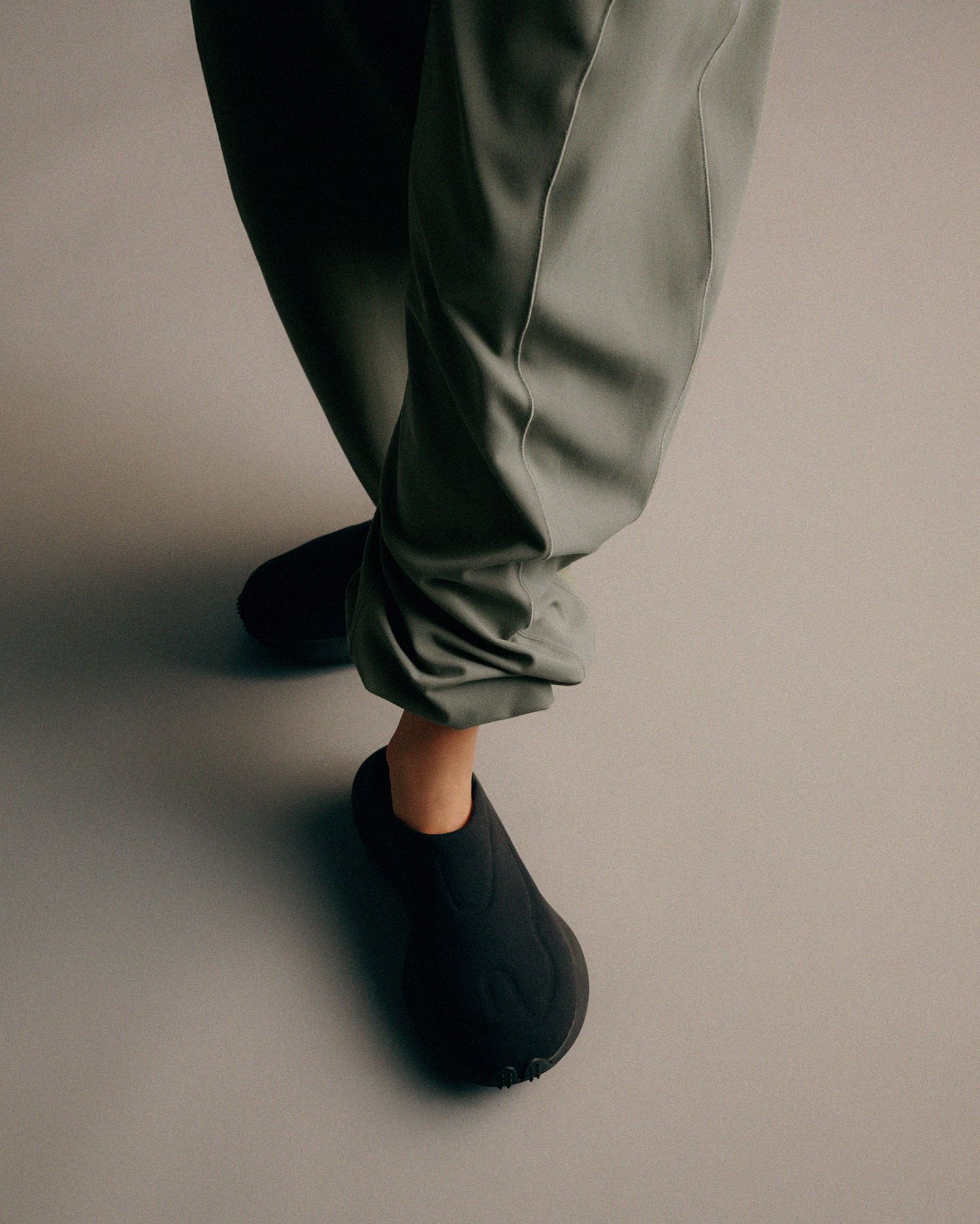 A person steps forward in a pair of black ZenMode mules.