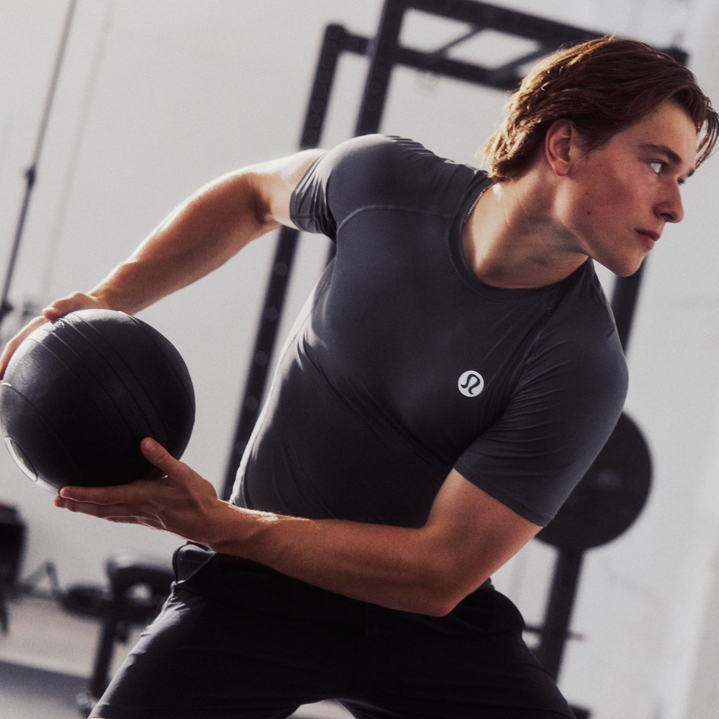 Professional Ice Hockey Player and lululemon Ambassador Macklin Celebrini throws a weighted ball while wearing the Unrestricted Power Shirt.