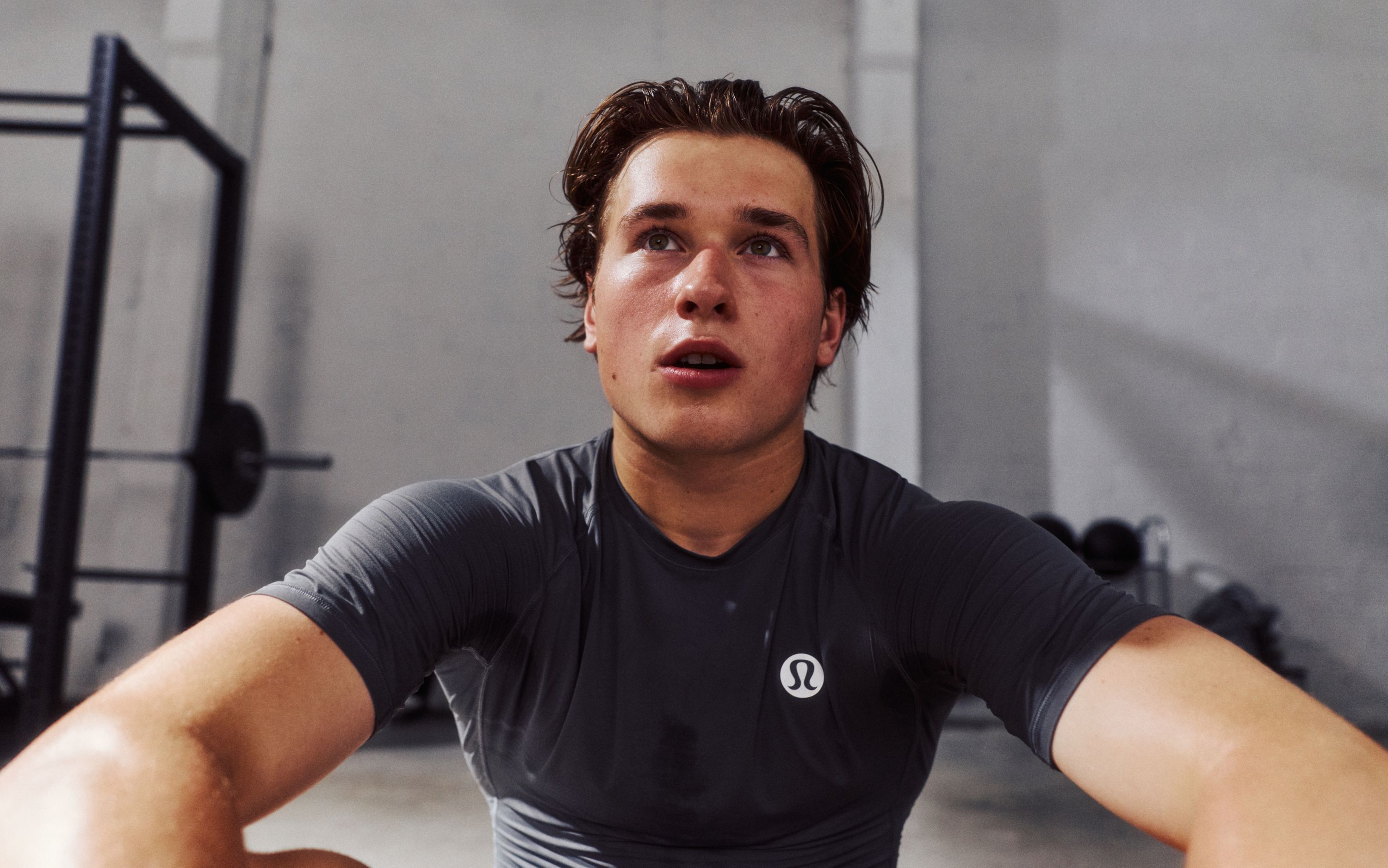A close-up image of Professional Ice Hockey Player and lululemon Ambassador Macklin Celebrini as he looks beyond.