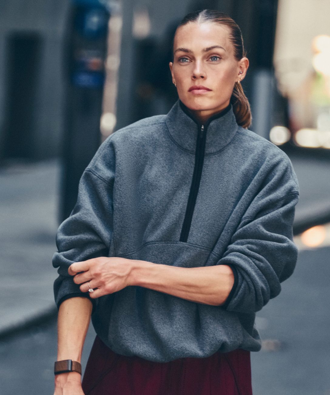 Une personne pose devant un mur gris. Elle porte des vêtements de la nouvelle collection d’automne 2026. 