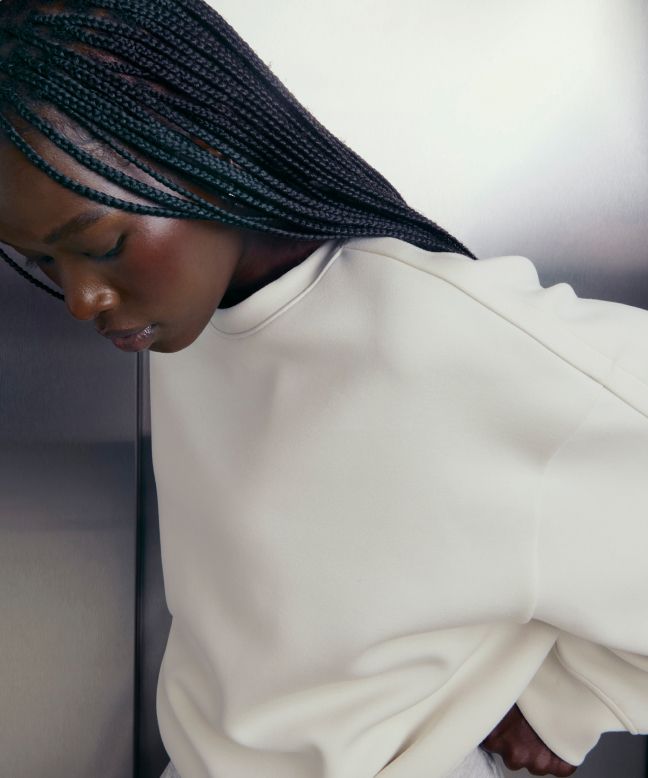 A person looks down while wearing the Smooth Spacer Oversized Crew.